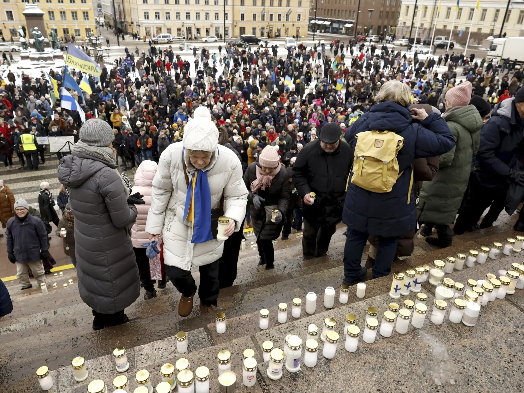 Na snímke ľudia kladú sviečky na schody katedrály počas spomienkového podujatia za obete vojny na Ukrajine 24. februára 2023 v Helsinkách.