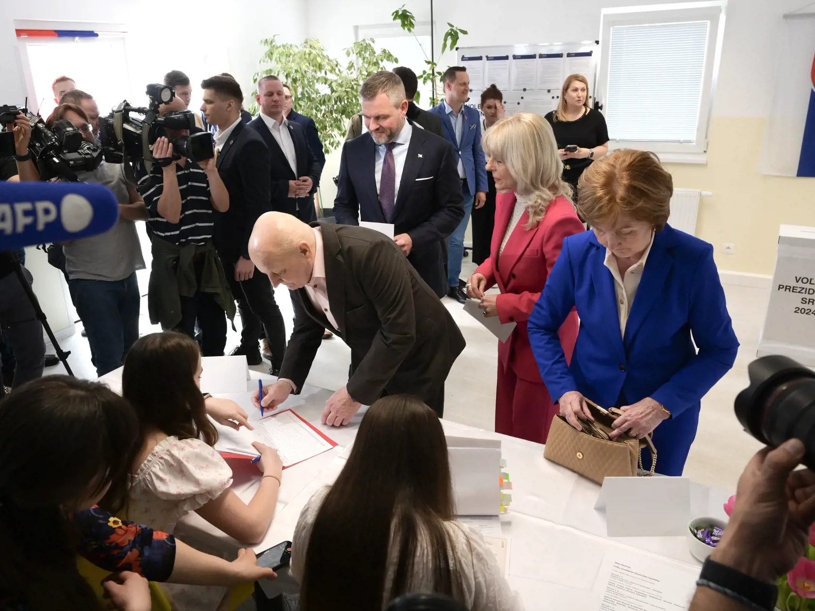 Na Slovensku sa v sobotu začalo v poradí šieste druhé kolo priamej voľby prezidenta Slovenskej republiky. Postúpili do neho Ivan Korčok a Peter Pellegrini, ktorým môžu občania dať svoj hlas vo volebných miestnostiach do 22 h. Na snímke vľavo v pozadí kandidát na prezidenta SR Peter 
Pellegrini, druhá sprava sestra a jeho rodičia pri registrácii vo volebnej miestnosti v druhom kole prezidentských volieb 6. apríla 2024 v miestnej škole v obci Rovinka. FOTO TASR - Pavel Neubauer
