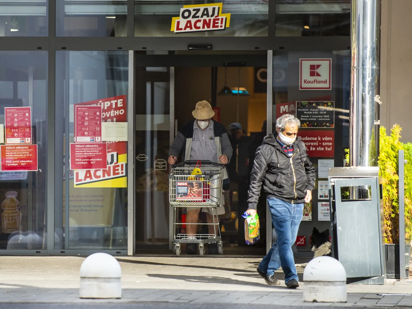 Od soboty 24.októbra až do nedele 1. novembra platí na celom Slovensku zákaz vychádzania s výnimkou ciest na testovanie, do práce, cesty na výkon podnikateľskej činnosti alebo inej obdobnej činnosti či zabezpečenia nevyhnutných potrieb, či pobytu v prírode v okrese bydliska. Na snímke zákazníci s ochrannými rúškami vychádzajú z potravín počas nákupu v nedeľu 25. októbra 2020 v Bratislave, FOTO TASR - Jakub Kotian