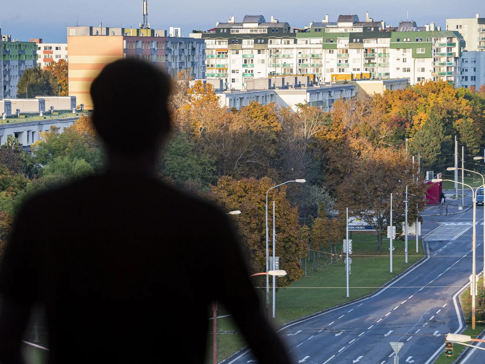 Od soboty 24.októbra až do nedele 1. novembra platí na celom Slovensku zákaz vychádzania s výnimkou ciest na testovanie, do práce, cesty na výkon podnikateľskej činnosti alebo inej obdobnej činnosti či zabezpečenia nevyhnutných potrieb, či pobytu v prírode v okrese bydliska. Na snímke muž sa pozerá na ulicu z okna bytu v bratislavskej mestskej časti Podunajské Biskupice v sobotu 24. októbra 2020. FOTO TASR – Jaroslav Novák