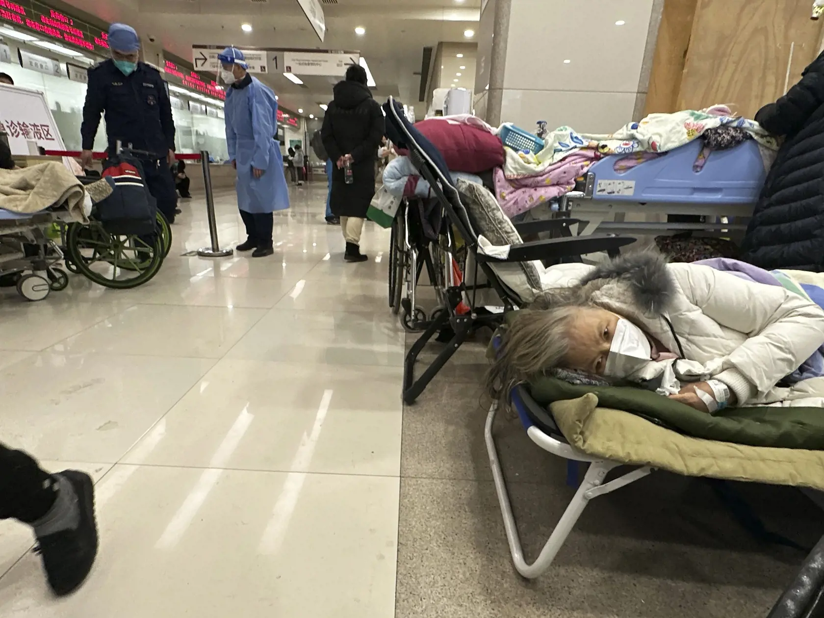 WA 5 Peking - Starší pacienti odpočívajú na lôžkach v ohraničenom priestore nemocnice v Pekingu v sobotu 31. decembra 2022. Predstavitelia Svetovej zdravotníckej organizácie sa v piatok stretli s čínskymi činiteľmi, ktorých vyzvali, aby poskytovali aktuálne dáta o súčasnom rýchlom šírení covidu v Číne.Aktuálne rýchle šírenie koronavírusu v Číne, ktoré nastalo po uvoľnení prísnych proticovidových opatrení, vyvoláva otázniky nad tým, či komunistická vláda v Pekingu zverejňuje pravdivé údaje o vývo