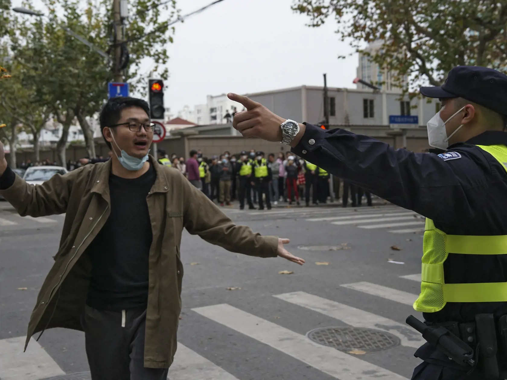 JB 10 Šanghaj - Demonštrant drží kvety v konfrontácii s čínskym policajtom počas protestu proti covidovým opatreniam v čínskom Šanghaji 27. novembra 2022. Do ulíc najväčšieho čínskeho mesta Šanghaj vyšli v nedeľu ráno demonštranti, ktorí požadovali ukončenie prísnych opatrení proti šíreniu covidu. Samosprávne orgány v niektorých čínskych mestách v pondelok zmiernili opatrenia proti šíreniu koronavírusu. Oficiálne to však neuviedli do spojitosti s prebiehajúcimi rozsiahlymi protestmi proti lockdo