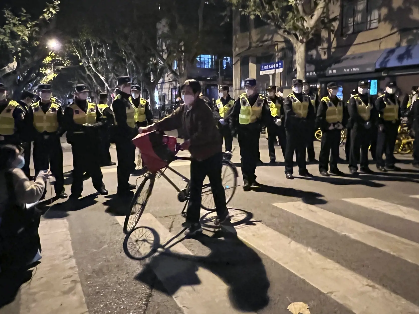 JB 50 Šanghaj - Čínski policajti blokujú miesto, kde sa zhromažďujú demonštranti počas protestu proti covidovým opatreniam v čínskom Šanghaji 27. novembra 2022. Do ulíc najväčšieho čínskeho mesta Šanghaj vyšli v nedeľu ráno demonštranti, ktorí požadovali ukončenie prísnych opatrení proti šíreniu covidu. Protest zorganizovali aj študenti elitnej univerzity v čínskej metropole Peking, informuje agentúra AFP. Protestné zhromaždenia vypukli v reakcii na tohtotýždňový smrtiaci požiar v čínskom región