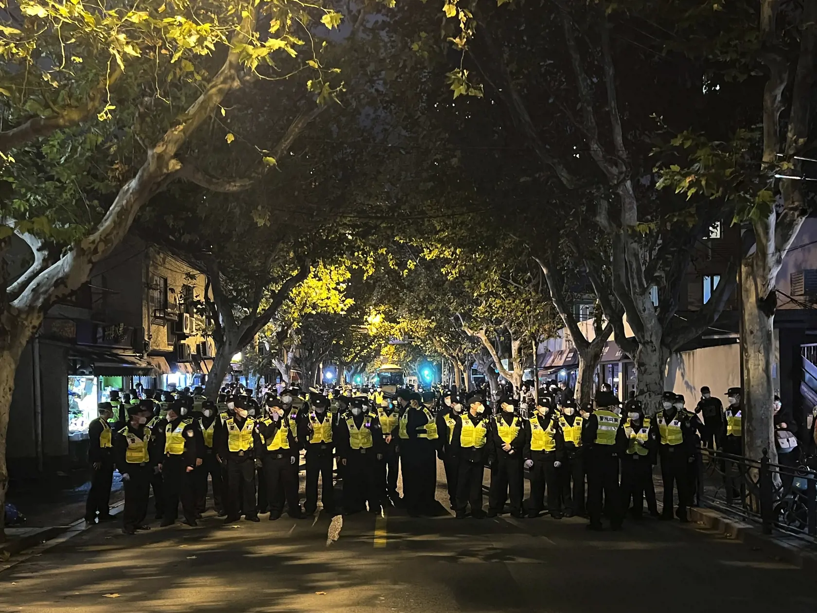 JB 51 Šanghaj - Čínski policajti blokujú miesto, kde sa zhromažďujú demonštranti počas protestu proti covidovým opatreniam v čínskom Šanghaji 27. novembra 2022. Do ulíc najväčšieho čínskeho mesta Šanghaj vyšli v nedeľu ráno demonštranti, ktorí požadovali ukončenie prísnych opatrení proti šíreniu covidu. Protest zorganizovali aj študenti elitnej univerzity v čínskej metropole Peking, informuje agentúra AFP. Protestné zhromaždenia vypukli v reakcii na tohtotýždňový smrtiaci požiar v čínskom región