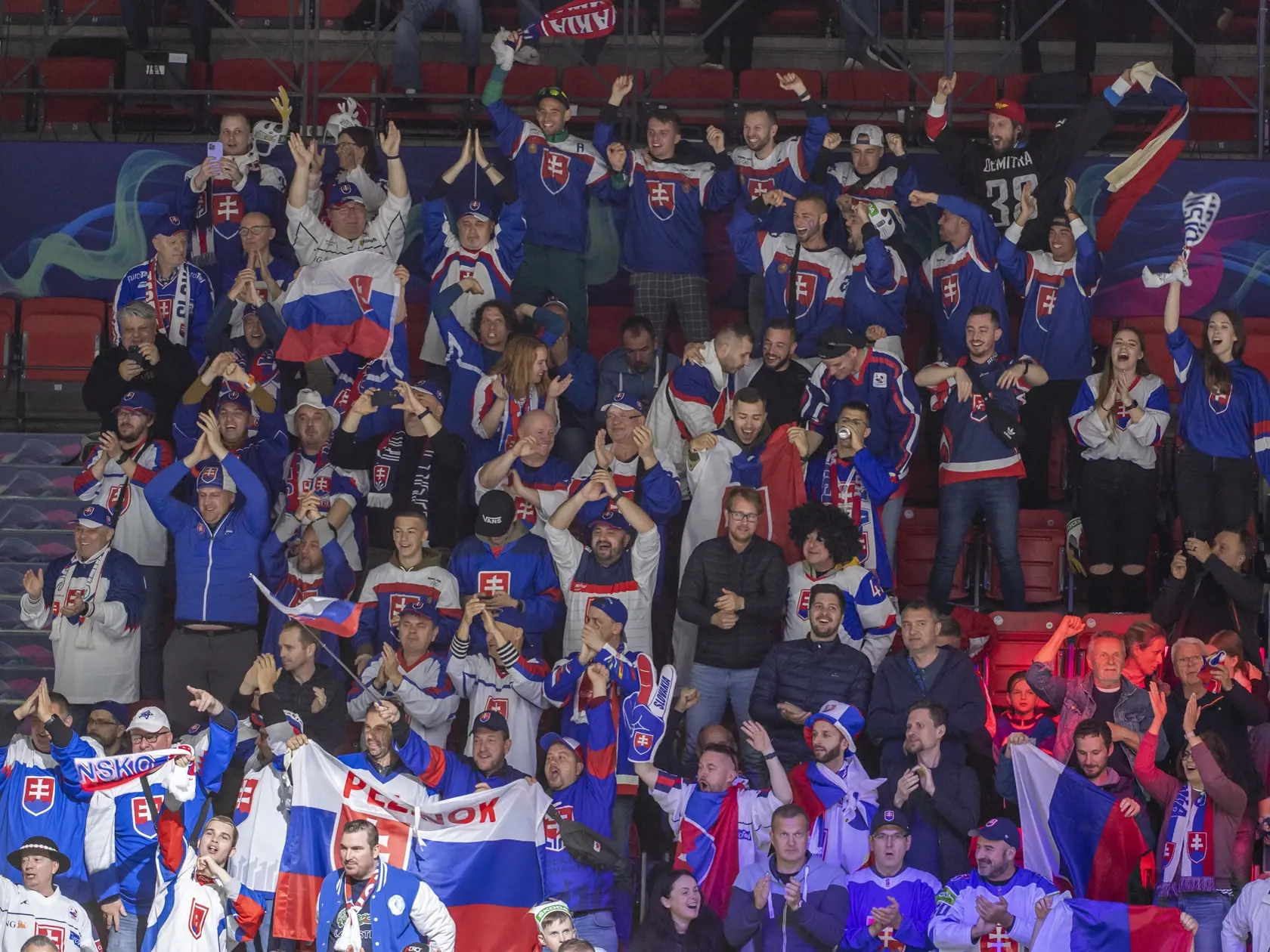 Na snímke slovenskí fanúšikovia sa tešia po strelení gólu v úvodnom zápase slovenskej hokejovej reprezentácie v základnej A - skupine Francúzsko - Slovensko na 85. majstrovstvách sveta v ľadovom hokeji v Helsinkách v piatok 13. mája 2022. Úvodný gól zápasu strelil Pavol Regenda. FOTO TASR - Martin Baumann