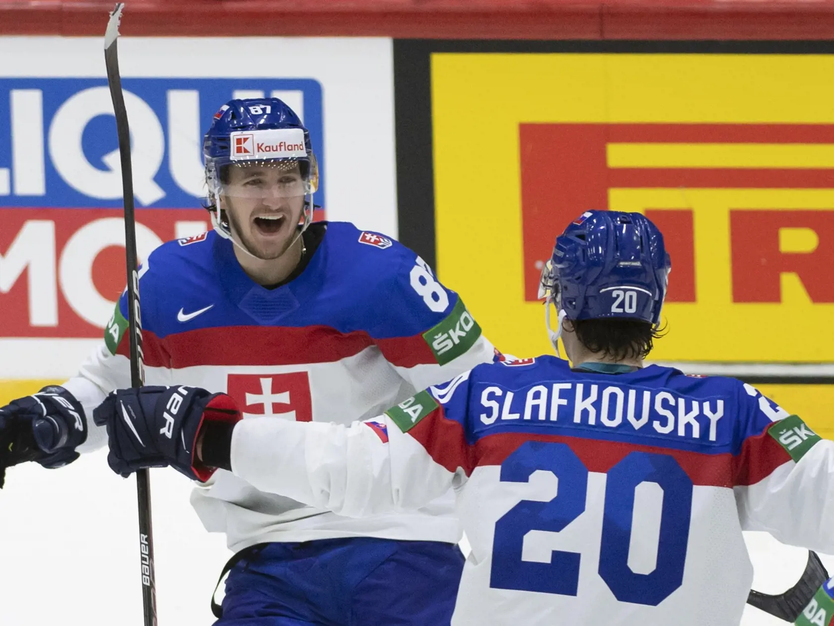Na snímke slovenský hokejista Pavol Regenda (vľavo) sa teší po strelení svojho druhého gólu, vpravo Juraj Slafkovský v úvodnom zápase slovenskej hokejovej reprezentácie v základnej A - skupine Francúzsko - Slovensko na 85. majstrovstvách sveta v ľadovom hokeji v Helsinkách v piatok 13. mája 2022. Vpravo Šimon Nemec, vľavo Juraj Slafkovský. FOTO TASR - Martin Baumann