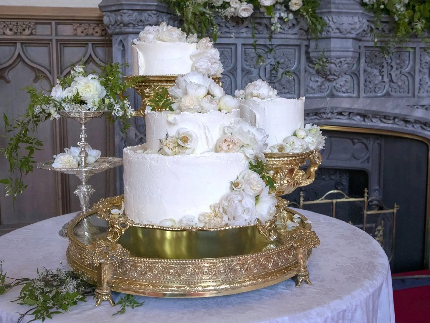 The wedding cake by Claire Ptak of London-based bakery Violet Cakes is pictured in Windsor Castle for the wedding of Britain's Prince Harry, Duke of Sussex and US fiancee of Britain's Prince Harry Meghan Markle on May 19, 2018. The wedding cake features elderflower syrup made at The Queenâ€™s residence in Sandringham from the estateâ€™s own elderflower trees, as well as a light sponge cake uniquely formulated for the couple. A filling made from Amalfi lemon curd and elderflower buttercream ties 