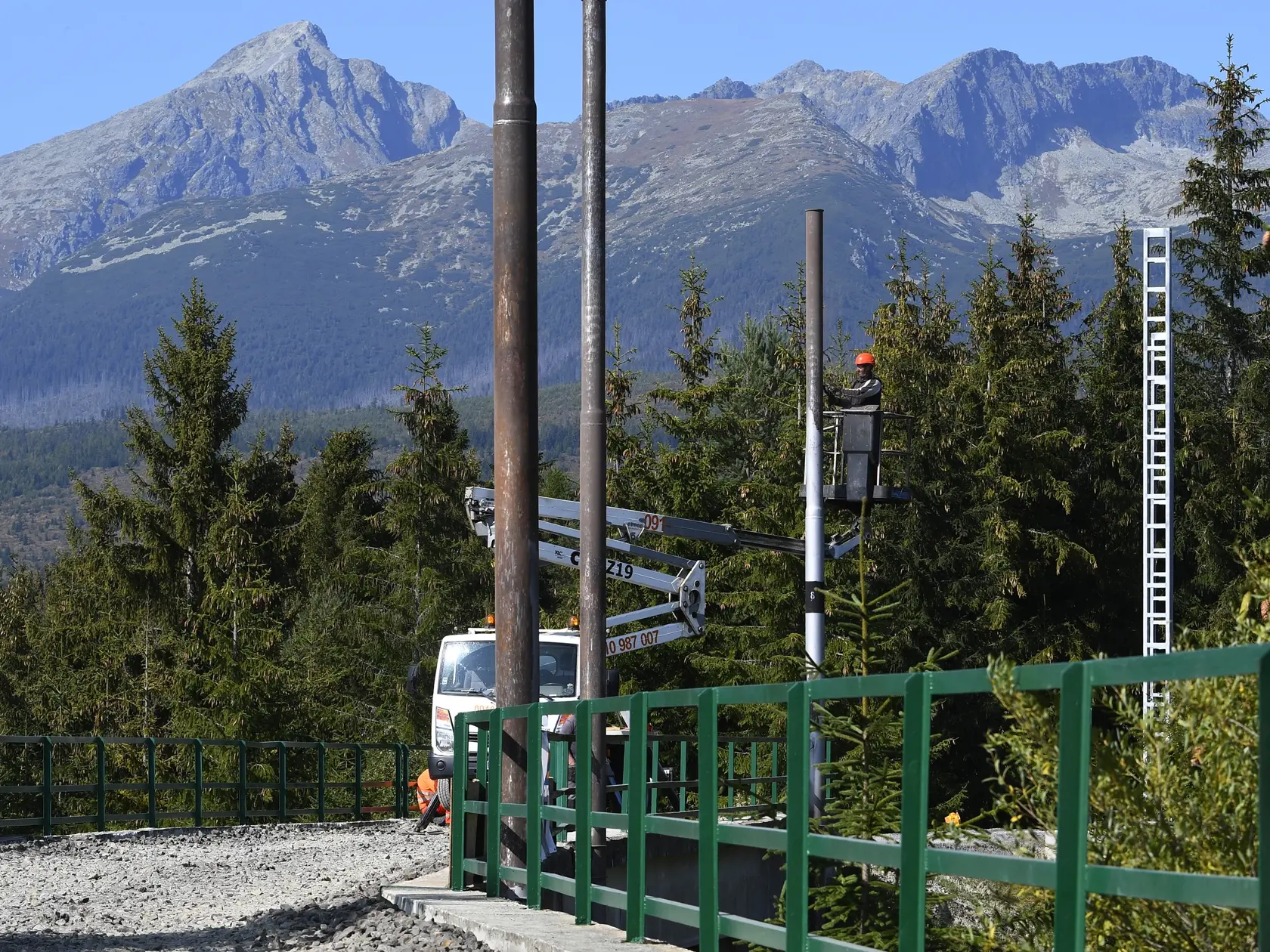 Trať zubačky zo Štrby na Štrbské Pleso počas rekonštrukcie ozubnicovej trati 24. septembra 2020. Od 6. júla 2020 sa začali rekonštrukčné práce. Dopravu cestujúcich počas sedemmesačnej výluky zabezpečí Železničná spoločnosť Slovensko (ZSSK) autobusmi. Na snímke čistenie starých stĺpov od farby nad koľajiskom zubačky bez koľají.  V Štrbe 24. septembra 2020. FOTO TASR – Milan Kapusta
