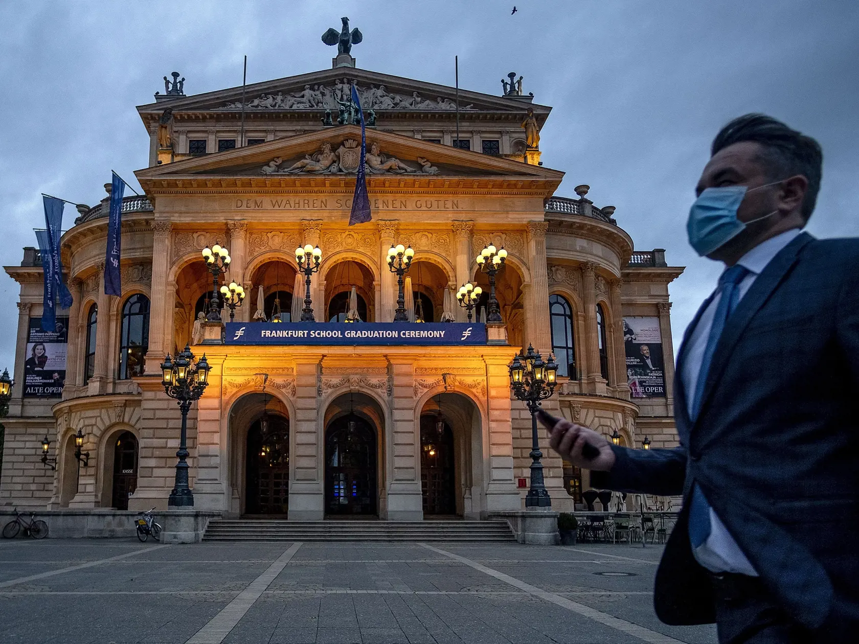 EBE 2 Frankfurt nad Mohanom - Na snímke muž s ochranným rúškom kráča po námestí okolo budovy starej opery vo Frankfurte nad Mohanom v Nemecku večer 8. októbra 2020.