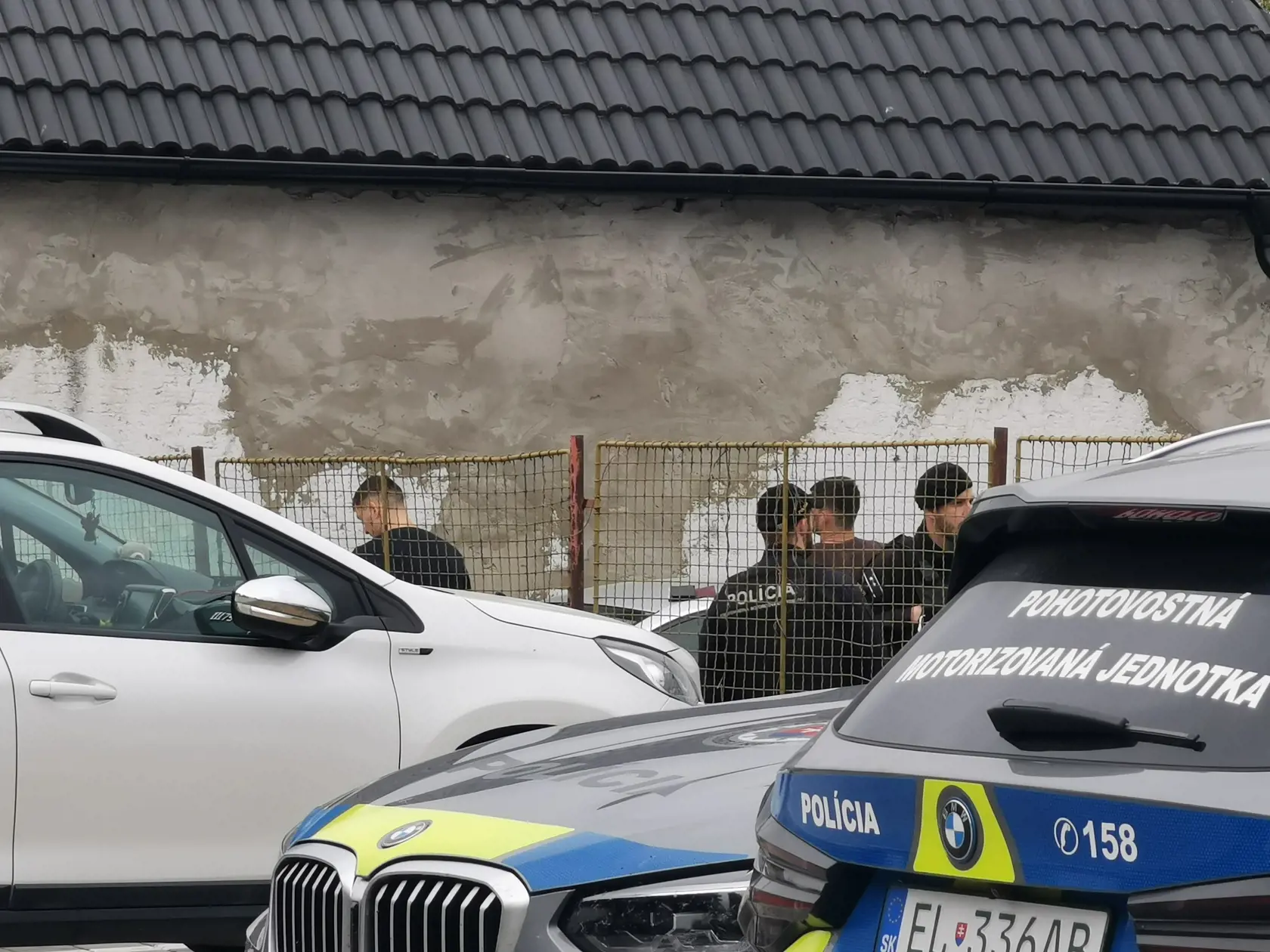 Pri miestnej škole mali kukláči pritlačených o múr dvoch mladých mužov.