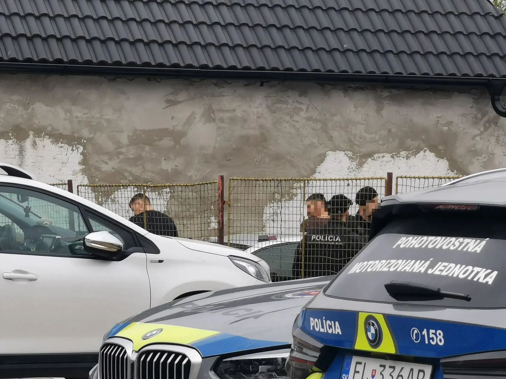 Pri miestnej škole mali kukláči pritlačených o múr dvoch mladých mužov.