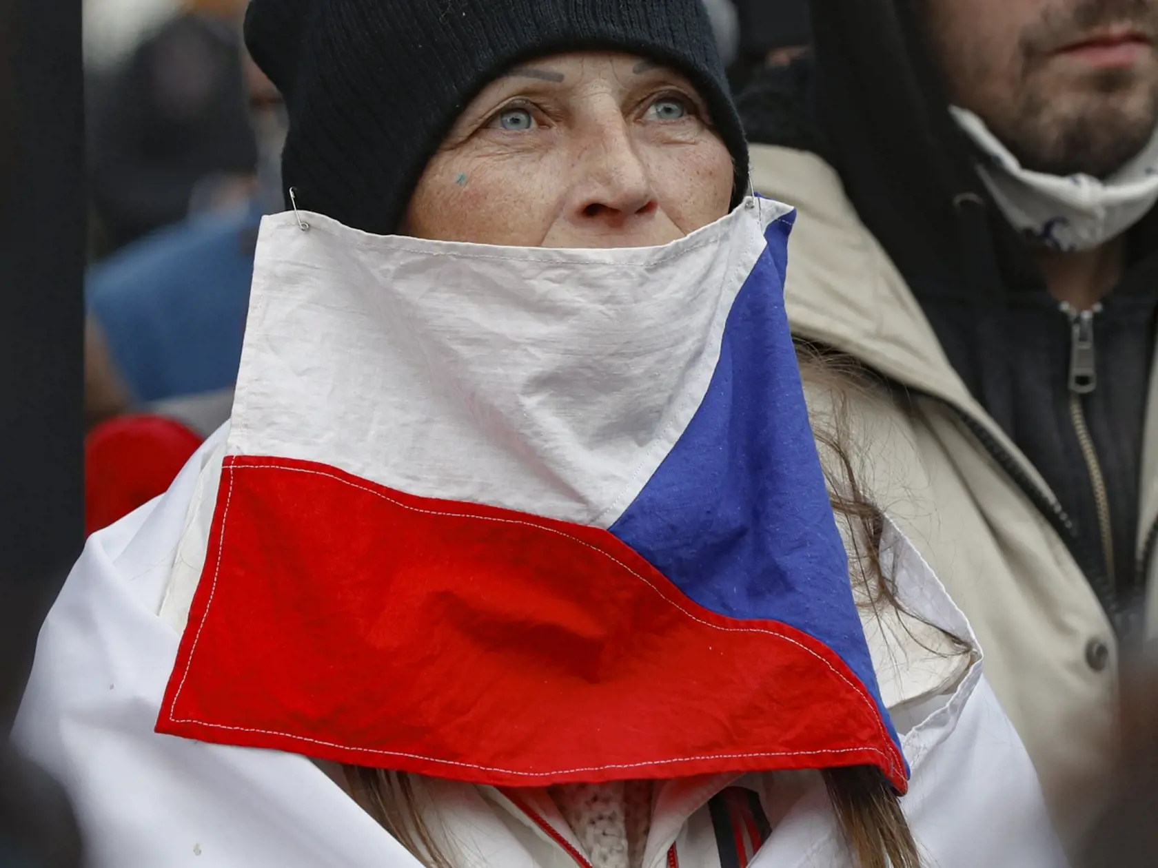 KK27 Praha - Na snímke žena s českou vlajkou počas protestu proti koronavírusovým opatreniam 28. októbra 2020 v Prahe. V Česku sa počet nakazených koronavírusom zvýšil za utorok o 15.663. Počet nových infikovaných sa tak po štyroch dňoch vrátil nad 15.000. Prípady nákazy sa napriek prísnym opatreniam nedarí výrazne znižovať. Denne zomrie okolo 100 ľudí s koronavírusom. FOTO TASR/AP
A woman wears a Czech flag as a mask as demonstrators gather to protest the COVID-19 preventative measures downtown