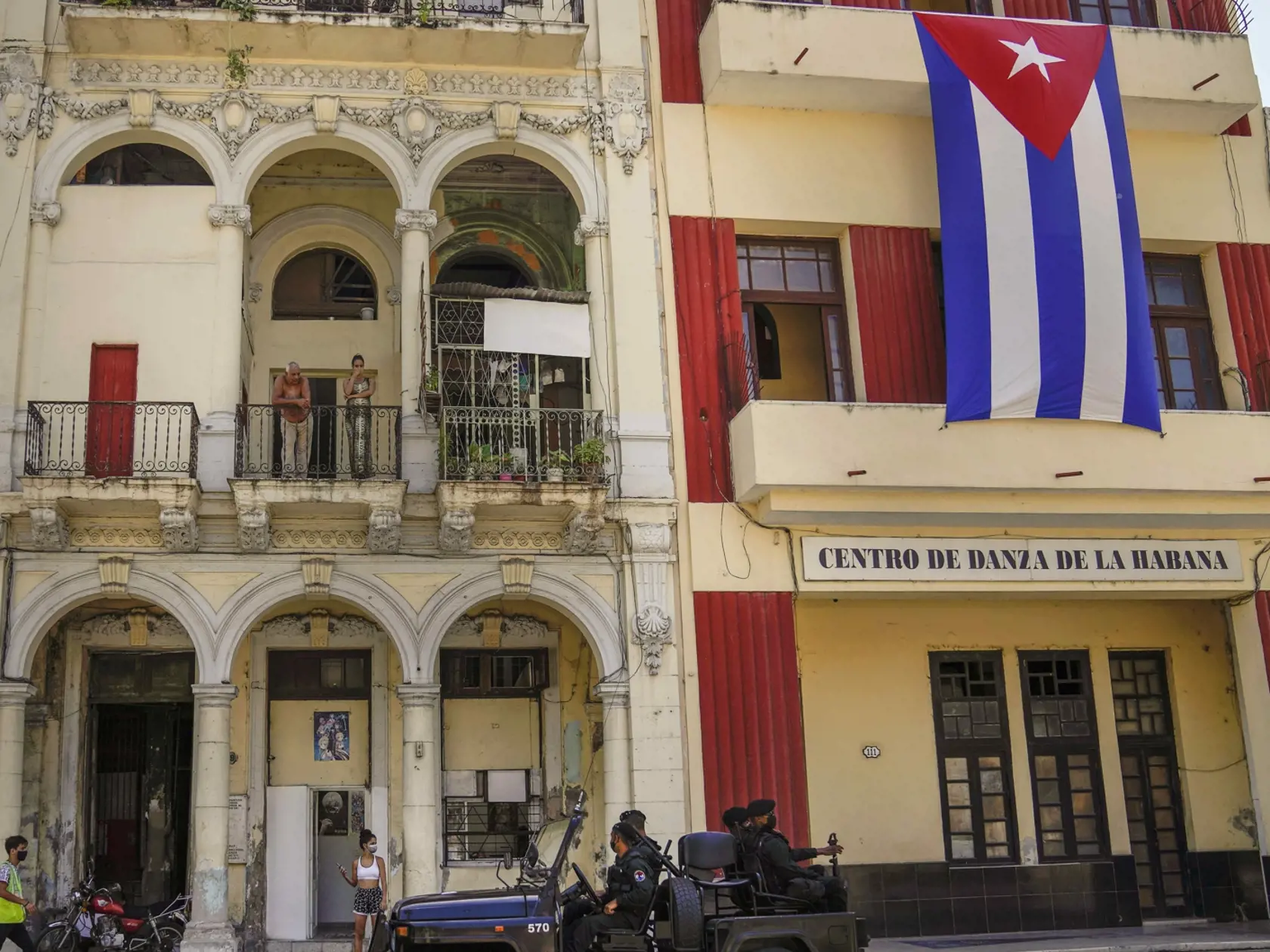 WA 45 Havava - Špeciálne policajné jednotky hliadkujú v uliciach Havany v stredu 21. júla 2021. FOTO TASR/AP  

Special forces police patrol the streets as they drive past a large Cuban flag hanging from the facade of a building, in Havana, Cuba, Wednesday, July 21, 2021. (AP Photo/Eliana Aponte)