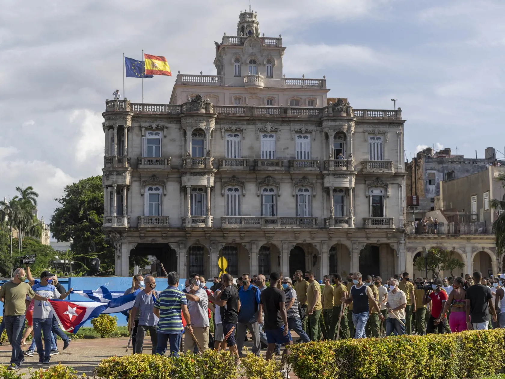WA 18 Havana - Stúpenci kubánskej vlády pochodujú pred veľvyslanectvom Španielska v Havane v nedeľu 11. júla 2021. Tisíce Kubáncov vyšli v nedeľu do ulíc miest od Havany na západe po Santiago de Cuba na východe krajiny počas zriedkavých protestov, ktoré patrili k najväčším na ostrove za posledné desaťročia. Účastníci vyjadrovali nespokojnosť s nedostatkom potravín a ďalších základných potrieb počas zhoršujúcej sa ekonomickej krízy, výpadkom prúdu i podľa ich slov nedbanlivosti vlády pri boji pro