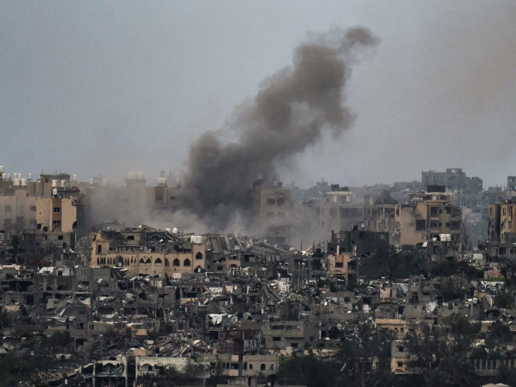 Dym stúpa pri explózii po izraelskom bombardovaní pásma Gazy, čo je viditeľné z juhu Izraela v piatok 8. marca 2024. Izraelská armáda bojuje s palestínskymi militantmi hnutia Hamas v pásme Gazy po útokoch Hamasu na Izrael 8. októbra.