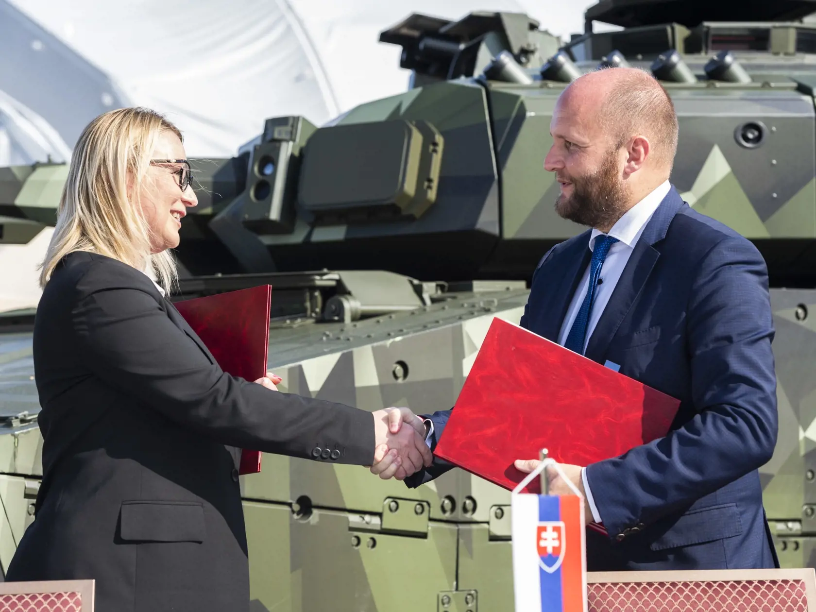 Na snímke zľava ministerka obrany Českej republiky Jana Černochová a minister obrany SR Jaroslav Naď (OĽaNO) si podávajú ruky po podpise zmluvy o spolupráci pri obstaraní pásových obrnených vozidiel CV-90 medzi Slovenskou republikou a Českou republikou na 11. ročníku Medzinárodných leteckých dní SIAF v priestoroch Leteckej základne Malacky-Kuchyňa v sobotu 27. augusta 2022. FOTO TASR - Jaroslav Novák