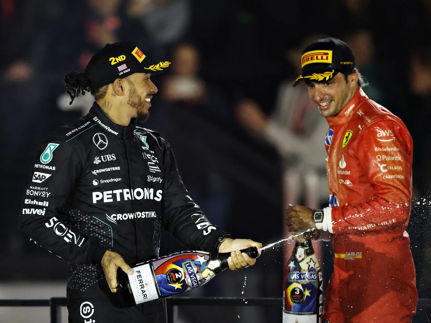 Lewis Hamilton a Carlos Sainz oslavujú pódiové umiestnenie. Práve Hamilton poslal Sainza preč zo Scuderie.