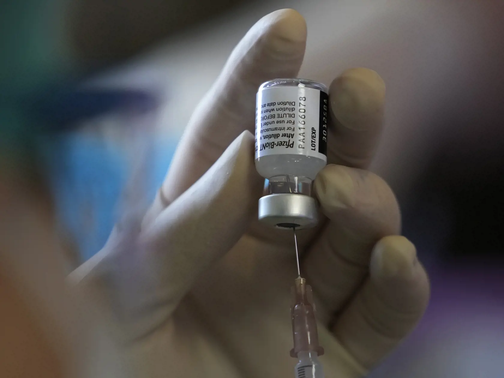 Zdravotníčka pripravuje ampulku s vakcínou Pfizer-BioNTech počas očkovania proti ochoreniu COVID-19 vo vakcinačnom centre.