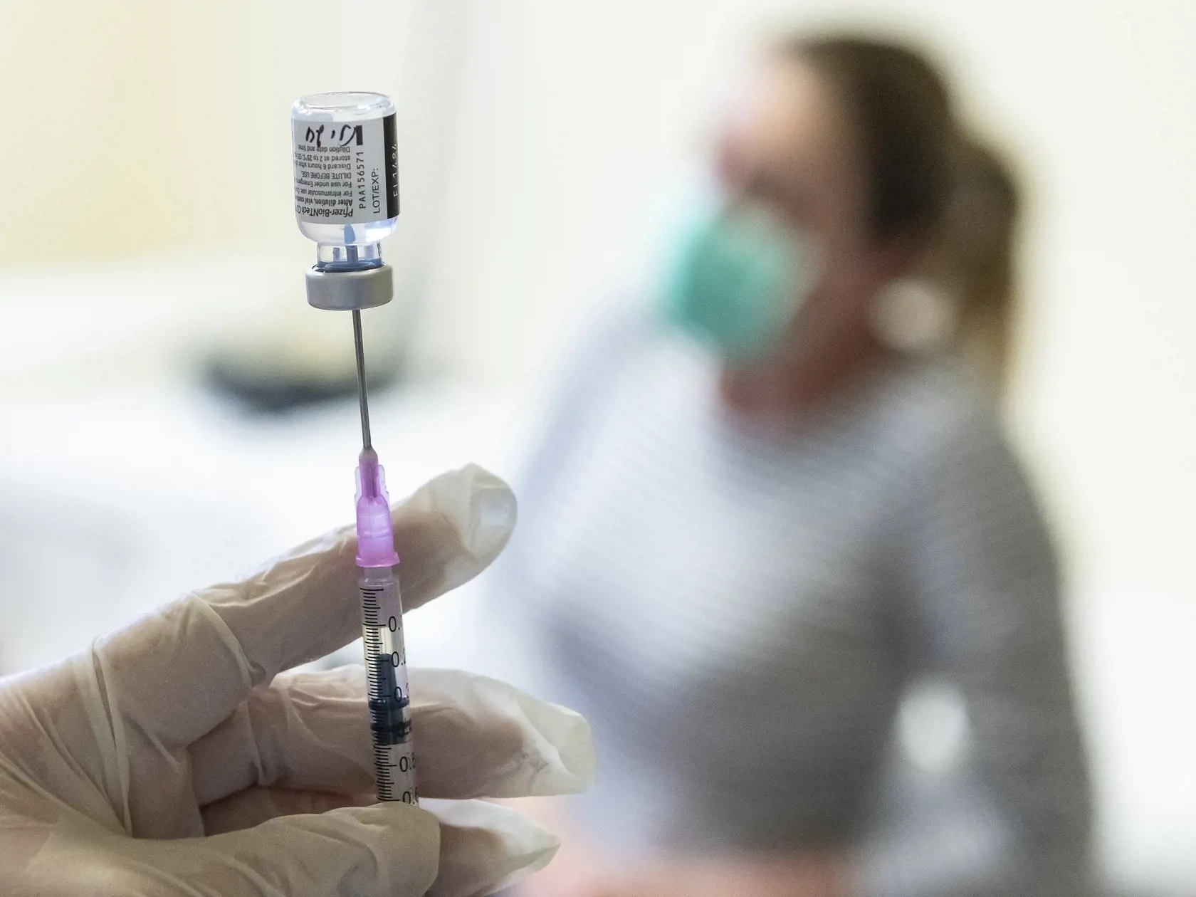 Zdravotná sestra naťahuje z ampulky do injekčnej striekačky vakcínu proti ochoreniu Covid-19 od konkorzia Pfizer/BionTech v nemocnici.