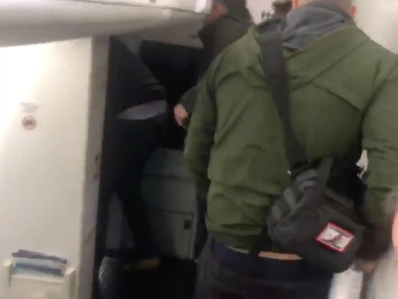 Princ Harry v čiernej zimnej bunde a tmavomodrej čiapke vystupuje z lietadla.