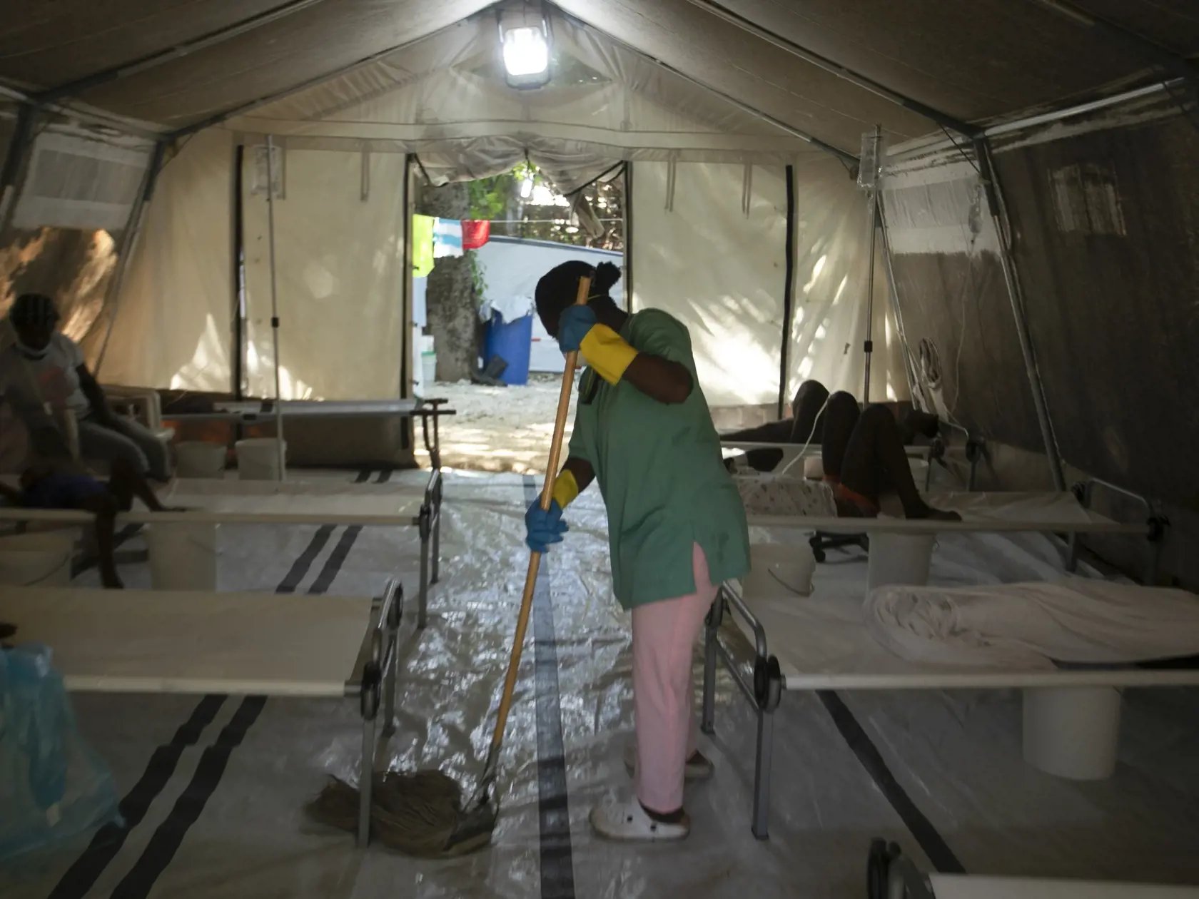 KK33 archív Port-au-Prince - Na archívnej snímke zo 7. októbra 2022 zamestnankyňa nemocnice umýva podlahu vo vnútri stanu, v ktorom sú hospitalizovaní ľudia s príznakmi cholery na klinike, ktorú prevádzkujú Lekári bez hraníc v Port-au-Prince na Haiti. Nedostatok vakcín proti cholere prinútil Svetovú zdravotnícku organizáciu (WHO), aby z bežného dvojdávkového očkovacieho modelu dočasne prešla na jednodávkový. Snaží sa tak zastaviť čoraz rýchlejšie sa šíriacu nákazu. FOTO TASR/AP
FILE - A hospital