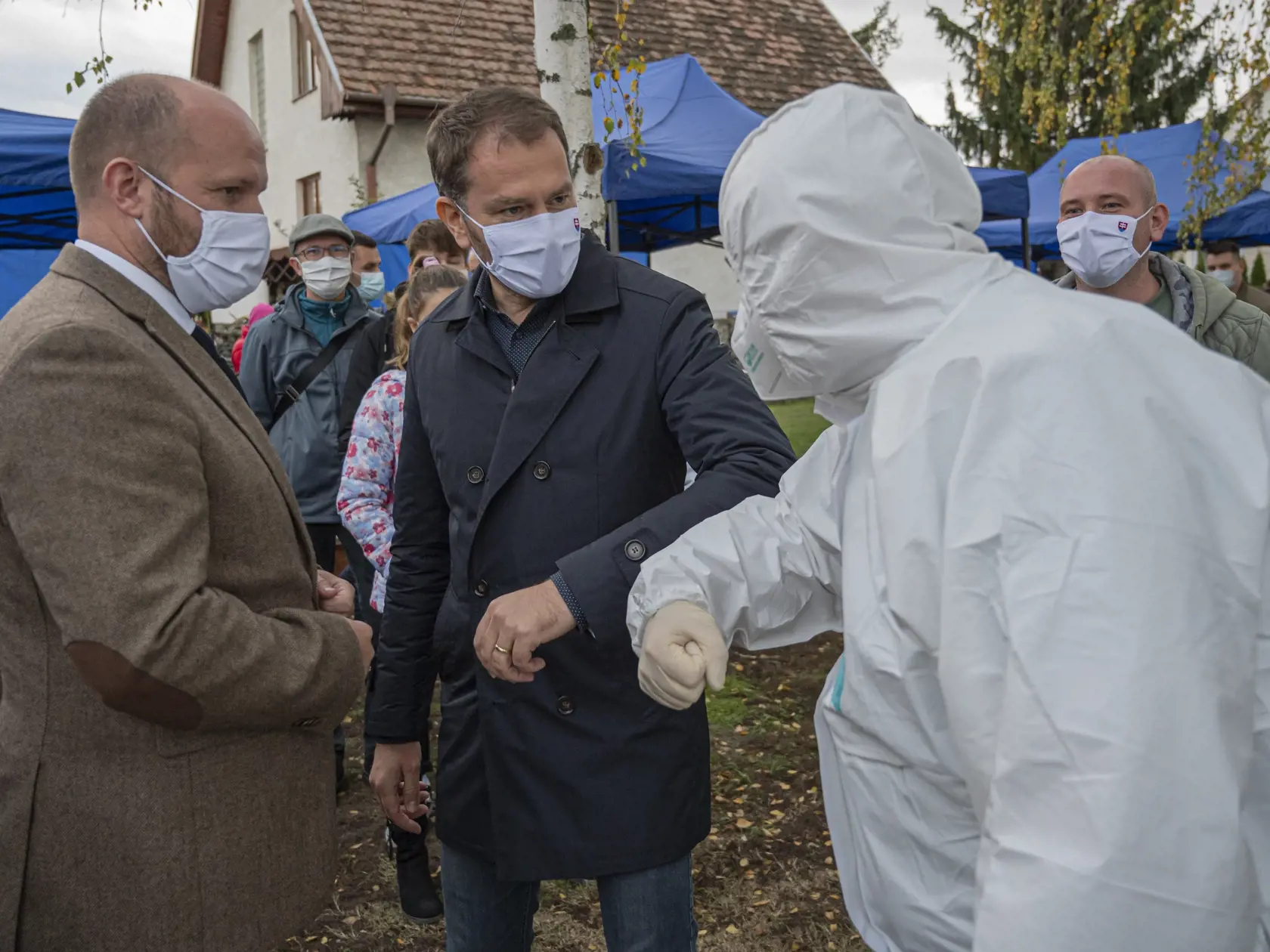 Na Slovensku sa začalo celoplošné testovanie na ochorenie COVID-19. Testovať sa bude od soboty 31. októbra do nedele 1. novembra. Vytvorených má byť viac ako 5000 odberných miest a 4901 odberných tímov. Na snímke uprostred predseda vlády SR Igor Matovič sa zdraví so zdravotníkom, vľavo minister obrany Jaroslav Naď v Hrubej Borši, okres Senec 31. októbra 2020. FOTO TASR - Michal Svítok