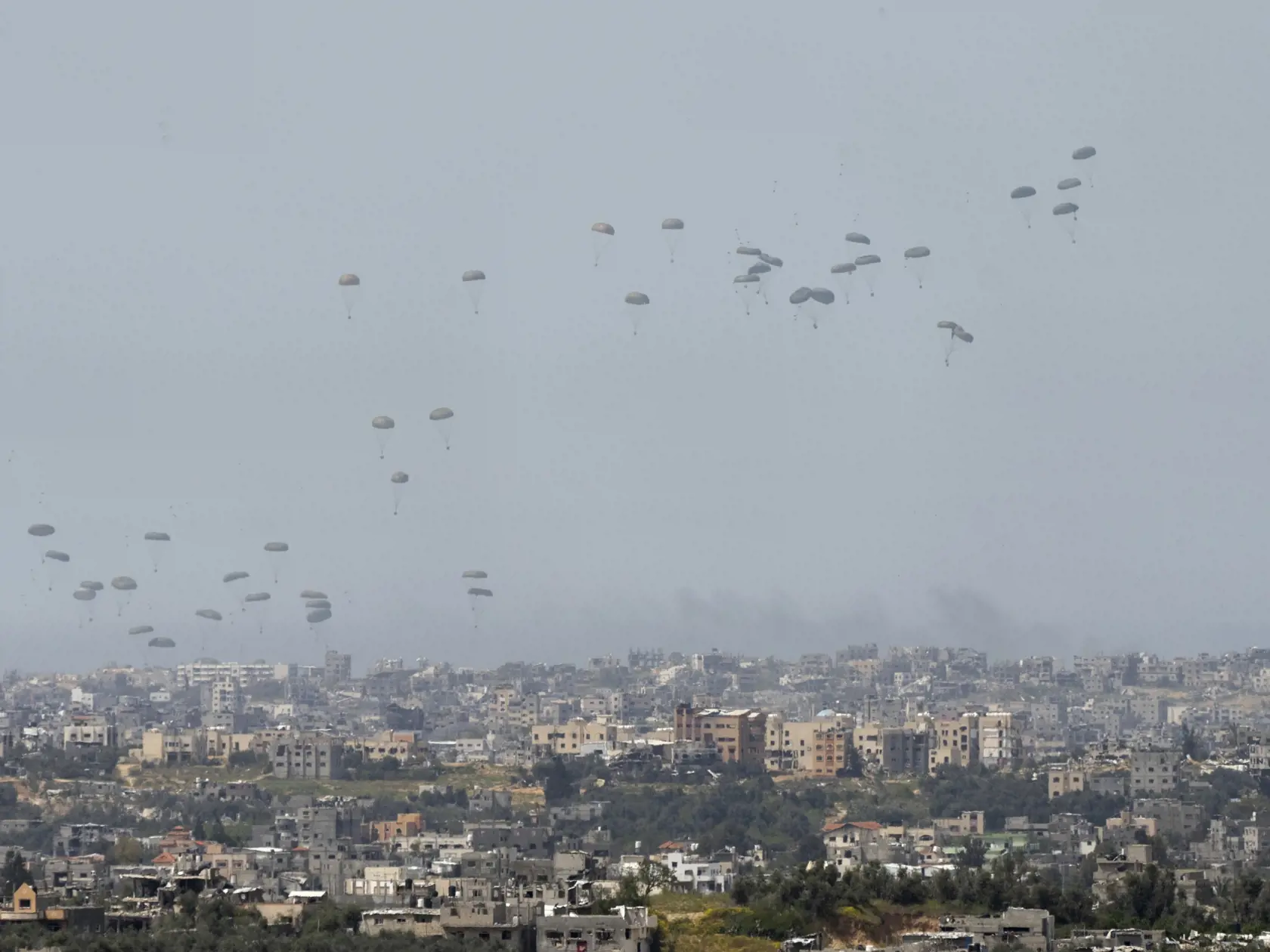 Lietadlo zhadzuje humanitárnu pomoc nad severom pásma Gazy, čo je viditeľné z juhu Izraela v stredu 27. marca 2024. Izraelská armáda bojuje s palestínskymi militantmi hnutia Hamas v pásme Gazy po útokoch Hamasu na Izrael 8. októbra.