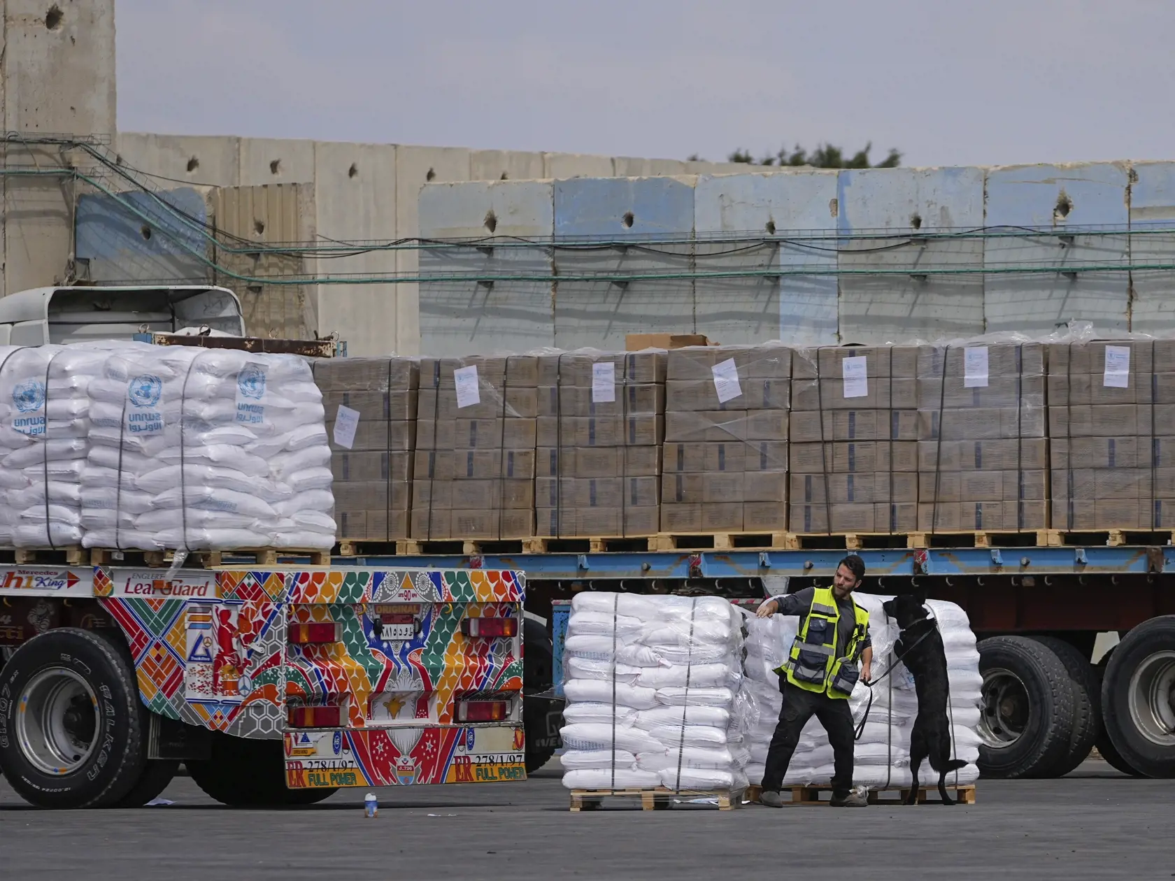 Na archívnej snímke zo 14. marca 2024 nákladné autá s humanitárnou  pomocou pre Pásmo Gazy prechádzajú cez kontorlu na hraničnom priechode Kerem Šalom na juhu Izraela. Izrael počas vojny s palestínskym hnutím Hamas úmyselne blokuje humanitárnu pomoc smerujúcu do Pásma Gazy, čím porušuje medzinárodné humanitárne právo. V piatok to uviedla medzinárodná charitatívna organizácia Oxfam.