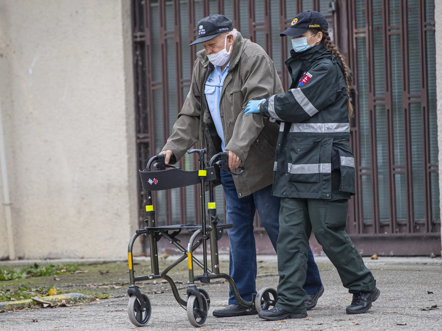 V nedeľu pokračovalo druhým dňom celoplošné testovanie na ochorenie COVID-19. Testovanie sa koná od soboty do 31. októbra do nedele 1. novembra. Na snímke policajtka odprevádza dôchodcu na testovanie na dostihovej dráhe v bratislavskej Petržalke, 1. novembra 2020. FOTO TASR - Michal Svítok