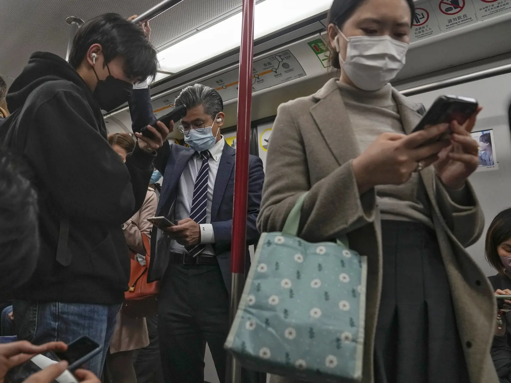 KK11 archív Hongkong - Na archívnej snímke zo 7. februára 2023 v Hongkongu cestujúci s ochrannými rúškami na tvári si pozerajú smartfóny počas cestovania metrom. V Hongkongu sa od 1. marca 2023 ruší povinnosť prekrytia horných dýchacích ciest na verejných priestranstvách, oznámil v utorok šéf tamojšej správy John Lee (Li Ťia-čchao). FOTO TASR/AP
FILE - Commuters wearing face masks browse their smartphones as they ride on a subway train in Hong Kong on Feb. 7, 2023. Hong Kong will lift its mask m