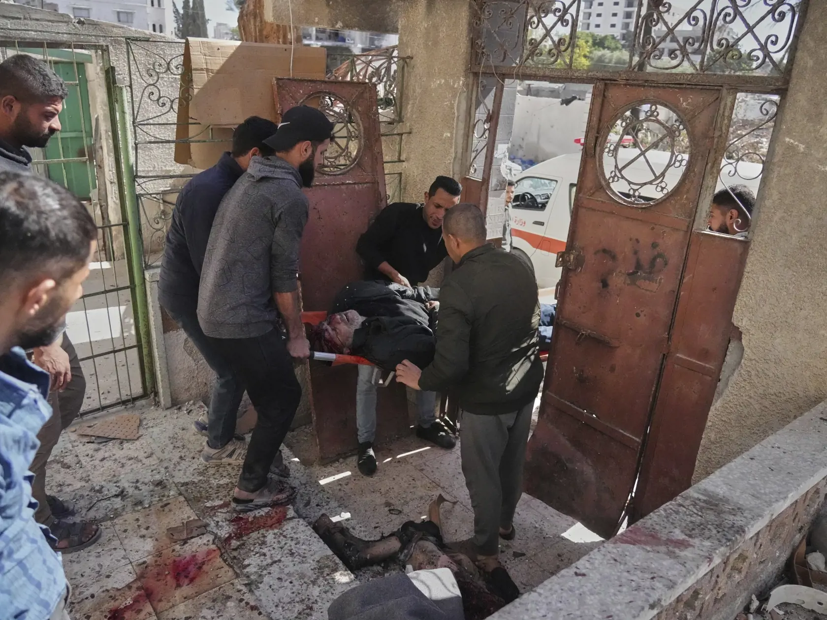 Palestínčania evakuujú zraneného muža po tom, ako jeho dom zasiahlo izraelské bombardovanie v Gaze v stredu 19. marca 2025.