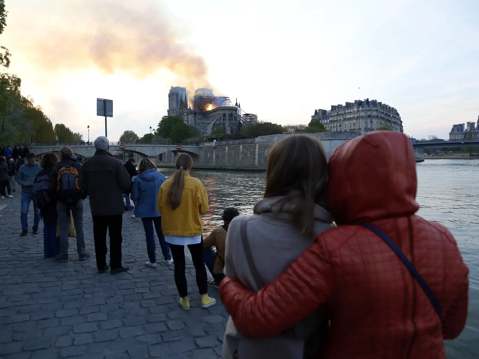 KK50 Paríž - Na snímke ľudia sledujú plamene a dym z horiacej Katedrály Notre-Dame  15. apríla 2019 v Paríži. V parížskej Katedrále Notre-Dame vypukol v pondelok popoludní požiar, ktorý môže súvisieť s prebiehajúcimi renovačnými prácami. FOTO TASR/AP
People watch as flames and smoke rise from Notre Dame cathedral as it burns in Paris, Monday, April 15, 2019. Massive plumes of yellow brown smoke is filling the air above Notre Dame Cathedral and ash is falling on tourists and others around the isl