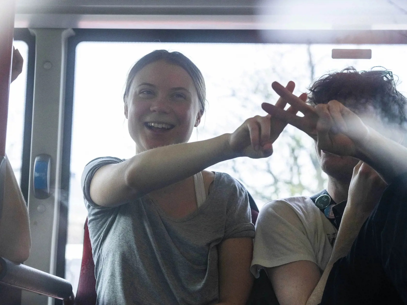 Na snímke klimatická aktivistka Greta Thunbergová ukazuje znak víťazstva po tom, čo ju zadržali a odviezli v autobuse s ďalšími zadržanými z hnutia Extinction Rebellion (XR) počas klimatického protestu v Haagu 6. apríla 2024.