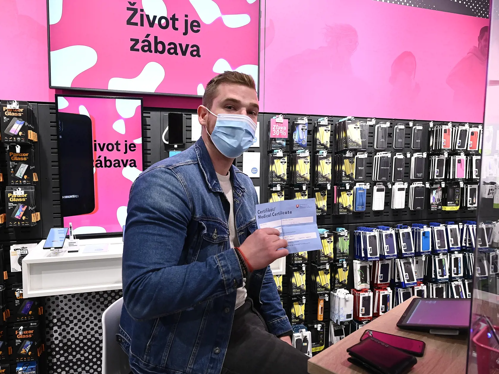 Zákazník v predajni mobilného operátora ukazuje antigénový certifikát na ochorenie COVID-19 s negatívnym výsledkom, s ktorým sa musel preukázať pri vstupe do predajne, 2. novembra 2020 v obchodnom centre Laugarício v Trenčíne. FOTO TASR - Radovan Stoklasa