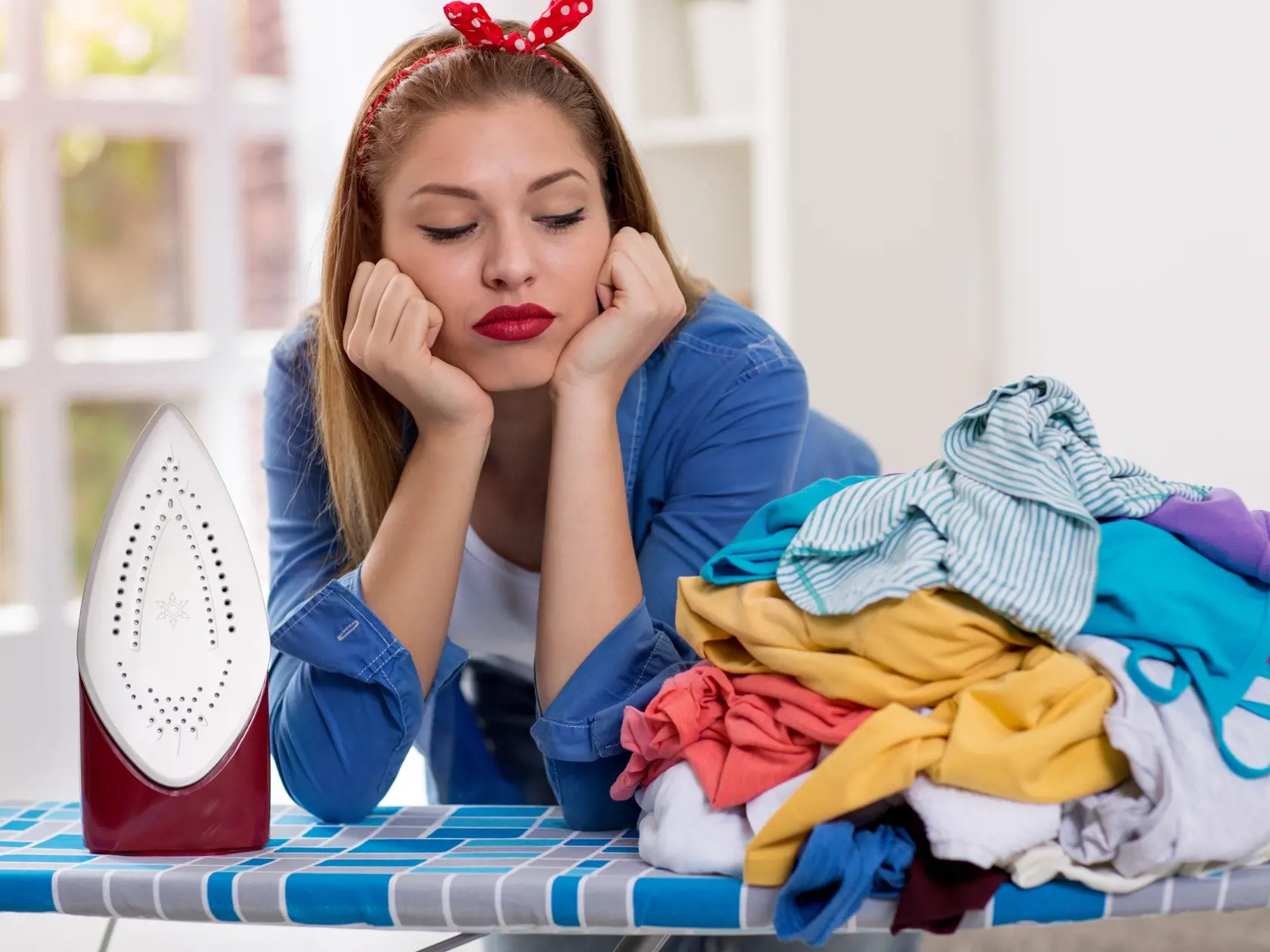 Lazy,Young,Woman,Looks,At,Laundry,On,Ironing,Board