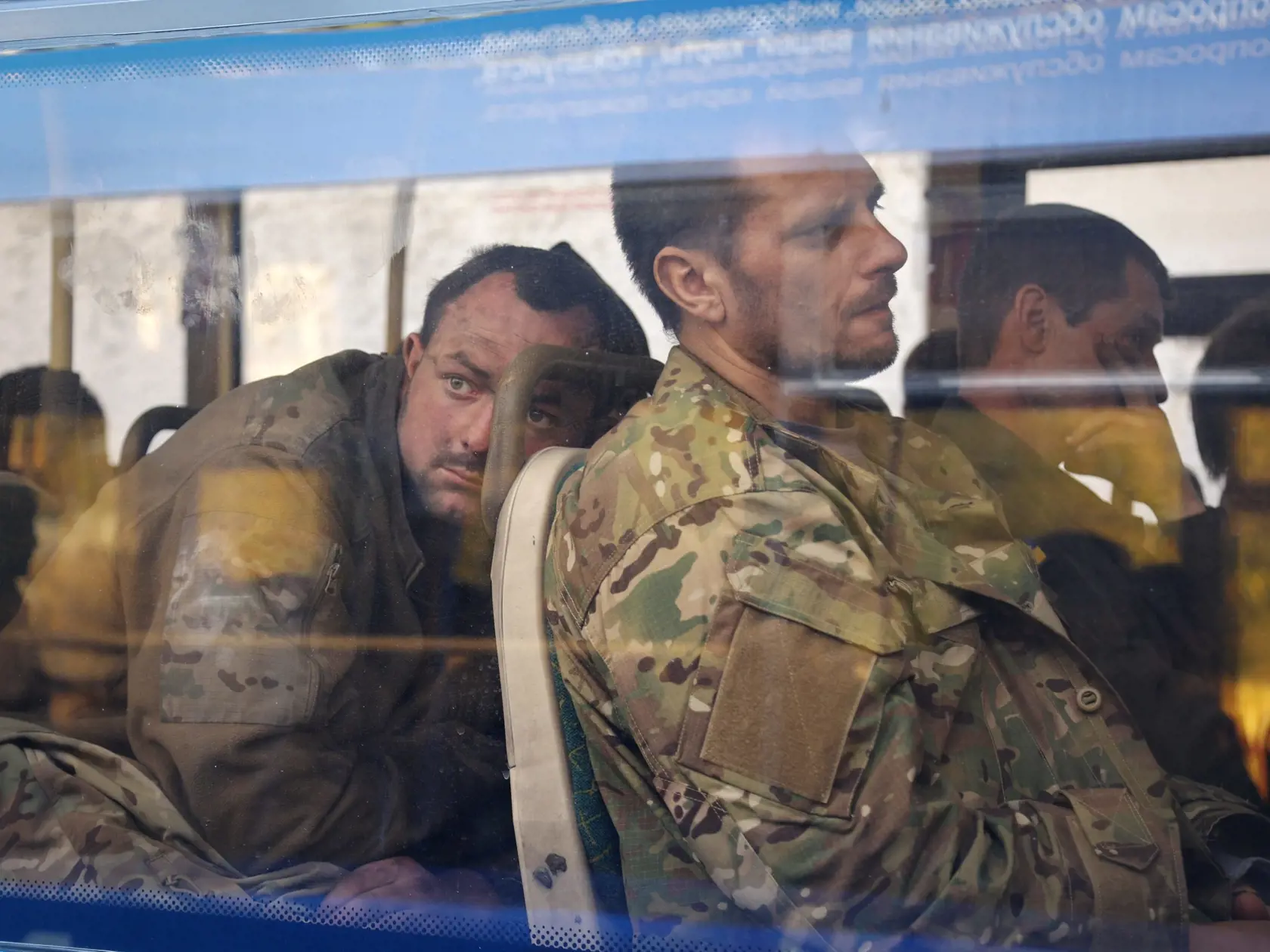 WA 18 Olenivka - Ukrajinskí vojaci, ktorí niekoľko týždňov odolávali útokom ruských síl v oceliarniach Azovstaľ v prístavnom meste Mariupol, sedia v autobuse po evakuácii neďaleko väznice v obci Olenivka v Doneckej oblasti na východe Ukrajiny v utorok 17. mája 2022. Sedem autobusov s ukrajinskými vojakmi údajne previezli do obcí v Donecku ovládaných Ruskom. Námestníčka ukrajinského ministra obrany Hanna Maľarová neskôr povedala, že Kyjev pozná počet ukrajinských vojakov, ktorí sa ešte nachádzajú