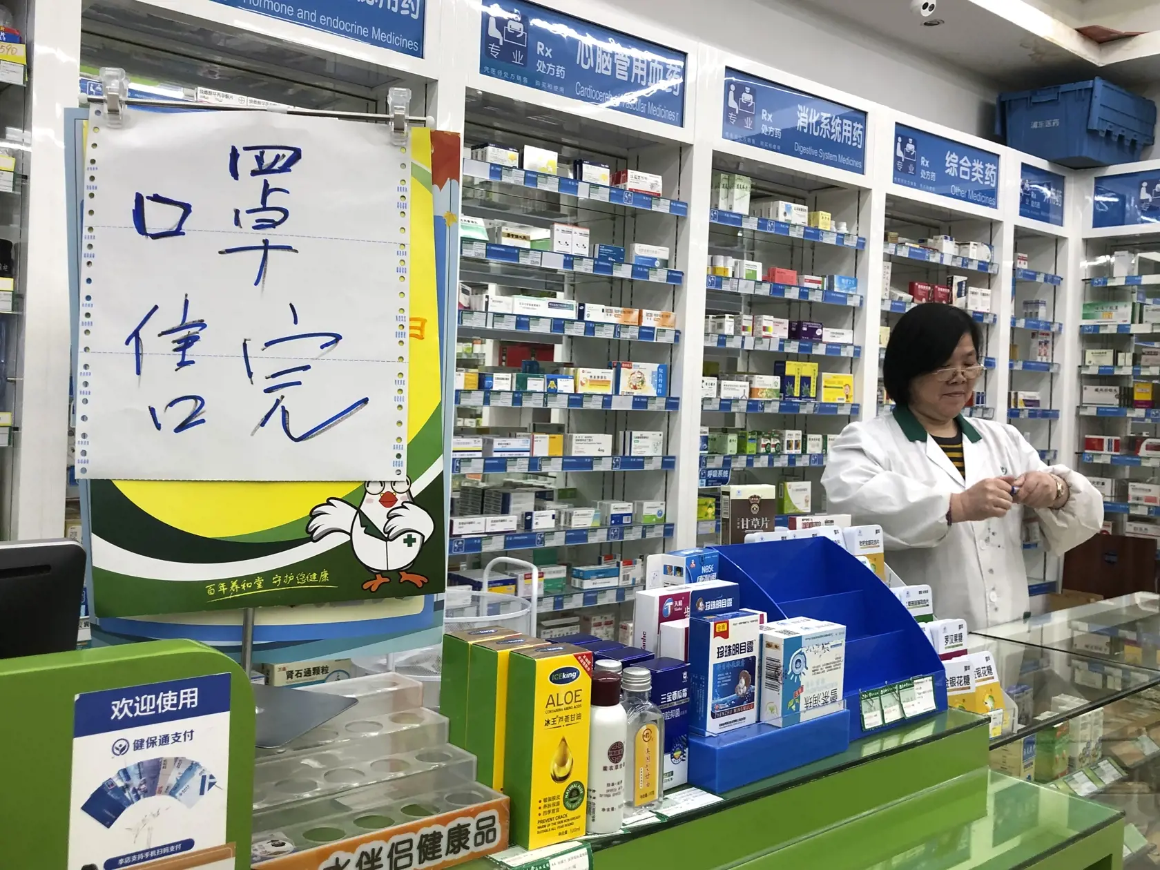 WA 15 Šanghaj - Farmaceutka stojí neďaleko oznamu o vypredaní ochranných rúšok v lekárni v čínskom meste Šanghaj v utorok 21. januára 2020. Na šesť stúpol v utorok počet obetí nákazy spôsobenej v Číne novým vírusom podobným SARS, informovala agentúra AFP. Tento nový, doteraz neznámy vírus spôsobujúci zápal pľúc sa prenáša  z človeka na človeka. Úrady vo Wu-chane, ktorý je predpokladaným zdrojom nákazy, zakázali turistom opustiť územie tohto mesta. Mesto takisto umiestnilo infračervené teplomery 