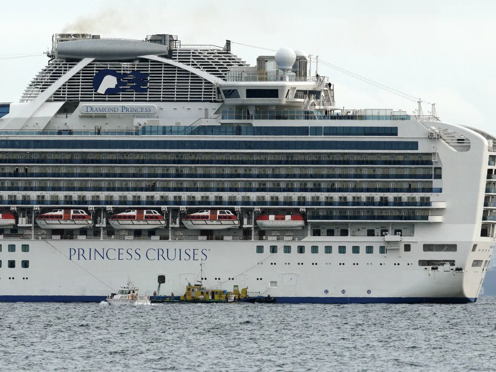 KK7 Jokohama - Malá loď sa plaví vedľa výletnej lode Diamond Princess, ktorá kotví v prístave v Jokohame 4. februára 2020. Japonskí zdravotníci vykonávajú rozsiahle lekárske kontroly u všetkých 3 700 cestujúcich a posádky výletnej lode, ktorí sa vrátili do krajiny po tom, čo jeden cestujúci bol pozitívne testovaný na koronavírus. FOTO TASR/AP
A small boat navigates near a cruise ship Diamond Princess anchoring off the Yokohama Port Tuesday, Feb. 4, 2020, in Yokohama, near Tokyo. Japanese health 