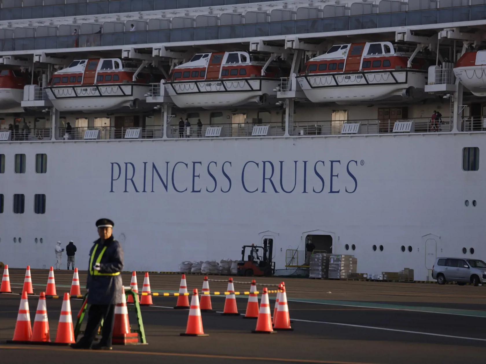 WA 29 Jokohama - Bezpečnostný pracovník hliadkuje pred výletnou loďou Diamond Princess, ktorá kotví v japonskej Jokohame vo štvrtok 13. februára 2020. Na palube japonskej výletnej lode Diamond Princess, ktorá je v karanténe pre šírenie koronavírusu, sa nachádza aj Slovák. Japonské ministerstvo zdravotníctva vo štvrtok oznámilo, že ďalších 44 ľudí na palube výletnej lode, ktorá je v karanténe pri meste Jokohama, malo pozitívne testy na nový typ koronavírusu. Na palube lode je viac ako 3500 pasaži