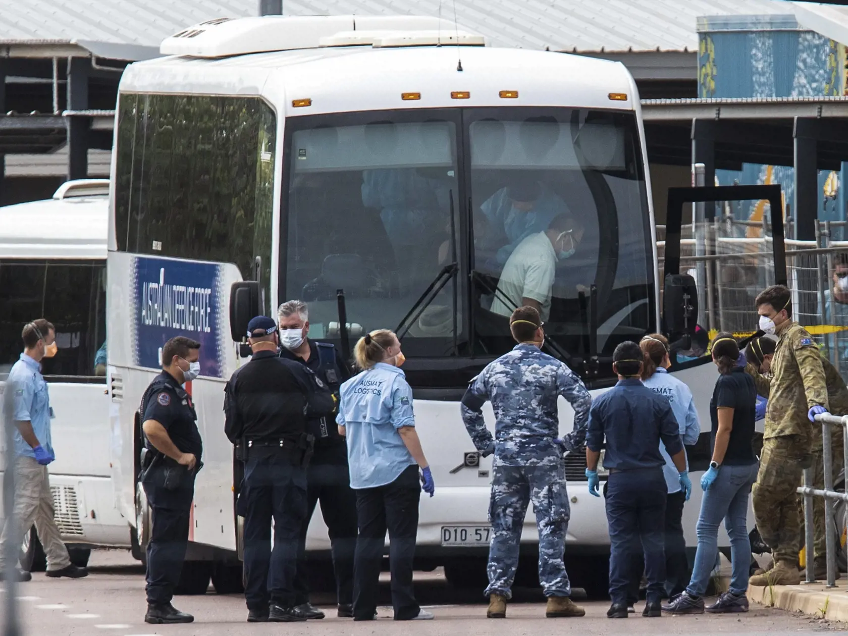 KK13 Darwin - Na snímke autobusy sú pripravené na evakuáciu ľudí do karanténneho zariadenia v austrálskom meste Darwin 20. februára 2020. Do austrálskeho mesta Darwin pricestovalo vo štvrtok približne 180 Austrálčanov, ktorých evakuovali z veľkej výletnej lode Diamond Princess, od začiatku februára kotviacej v prístave japonského mesta Jokohama. FOTO TASR/AP
Government agencies gather beside buses to be used to take evacuees to a quarantine facility after arriving in Darwin, Australia, Thursday,
