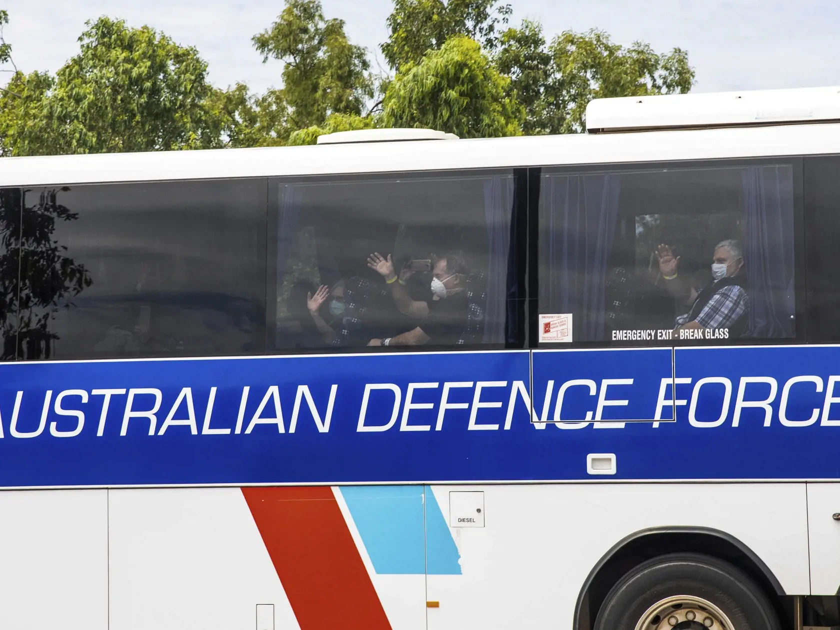 KK12 Darwin - Evakuovaní ľudia z výletnej lode Diamond Princess mávajú z autobusu po príchode do austrálskeho mesta Darwin 20. februára 2020. Do austrálskeho mesta Darwin pricestovalo vo štvrtok približne 180 Austrálčanov, ktorých evakuovali z veľkej výletnej lode Diamond Princess, od začiatku februára kotviacej v prístave japonského mesta Jokohama. FOTO TASR/AP
Evacuees wear masks and wave as they are bussed to a quarantine facility after arriving in Darwin, Australia, Thursday, Feb. 20, 2020. 