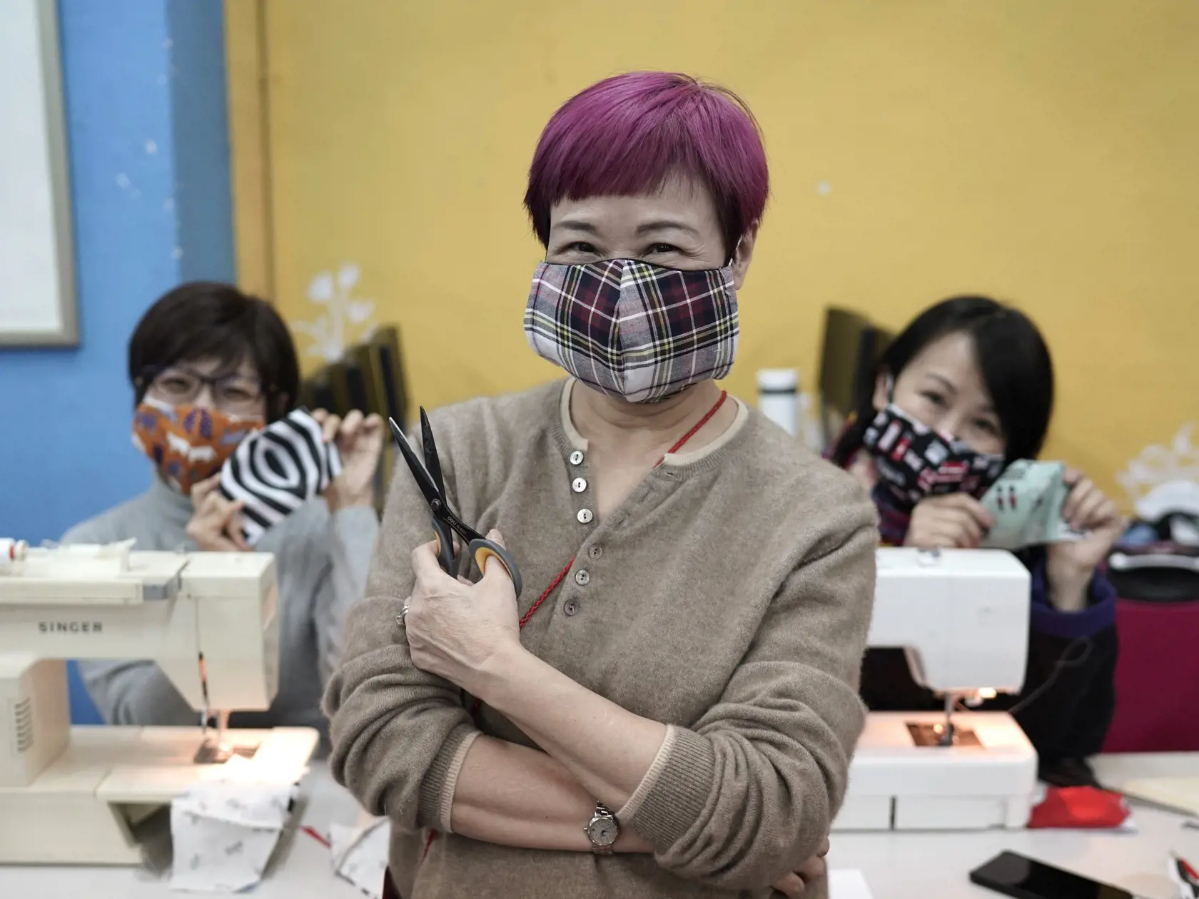 KK40 Hongkong - Dobrovoľníčky pózujú s ušitými bavlnenými rúškami v Hongkongu 17. februára 2020. Dobrovoľníci z hongkonskej divadelnej skupiny šijú opakovane použiteľné ochranné bavlnené rúška pre tých, ktorí nemajú k nim prístup alebo si ich nemôžu dovoliť. Počet obetí epidémie nového koronavírusu v Číne sa vo štvrtok 20. februára 2020 zvýšil na 2112 po tom, ako infekcii podľahlo ďalších 108 ľudí v najviac postihnutej provincii Chu-pej v strednej časti krajiny - epicentre šírenia nákazy. FOTO T