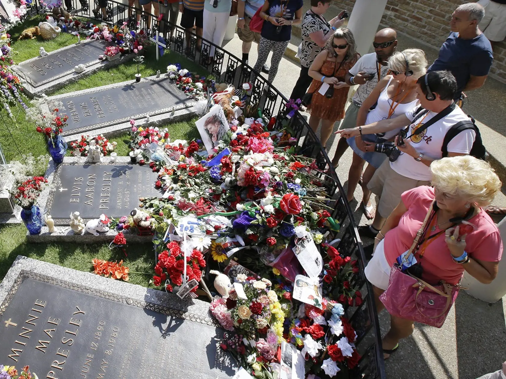 WA 20 archív Memphis - Na archívnej snímke zo 16. augusta 2012 fanúšikovia Elvisa Presleyho stoja pri hrobe speváka v Gracelande v Memphise.Domov Elvisa Presleyho, Graceland v Memphise, ktorý je turistickou atrakciou zameranou na život a hudbu tohto speváka, privítal v pondelok 2. mája 2016 20-miliónteho platiaceho návštevníka. Informovali o tom jeho prevádzkovatelia, ktorých oznámenie prevzala tlačová agentúra AP. Spoločnosť Elvis Presley Enterprises uviedla, že jubilejným návštevníkom sa stala