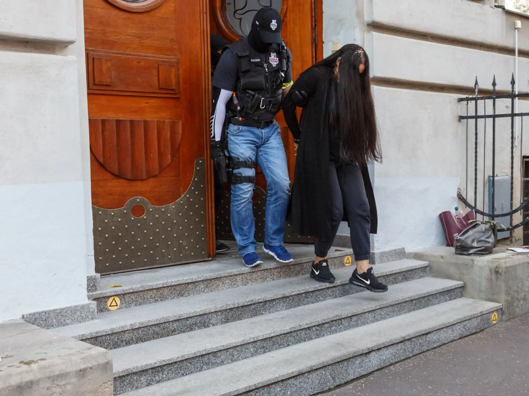 Alena Zsuzsová krátko po svojom zadržaní a obvinení mala veľmi dlhé vlasy. Vtedy ich používala aj na to, aby ju nemohli nafotiť fotografi. Všimnite si aj jej tenisky pre porovnanie s tým, čo nosí teraz (uvidíte v ďalších fotkách).