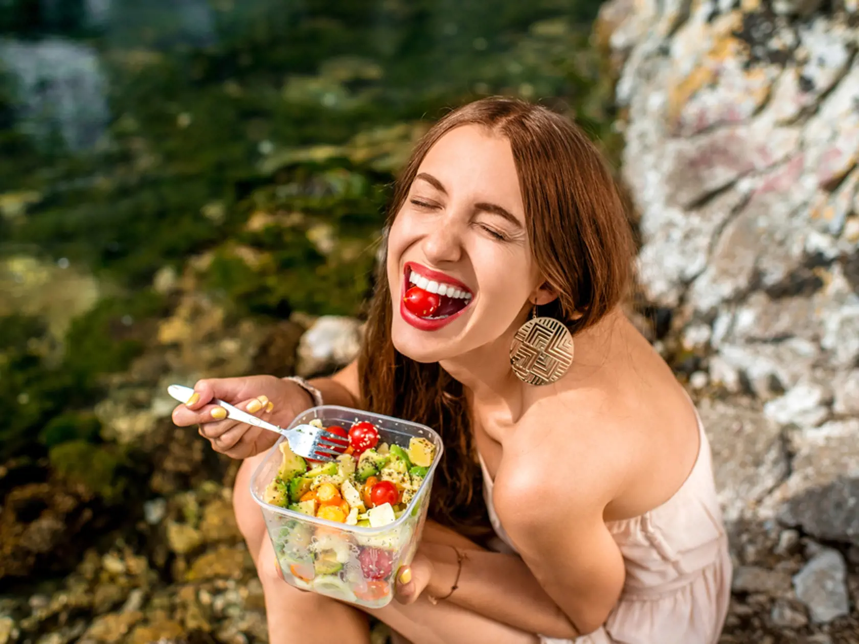 Woman,Eating,Healthy,Salad,From,Plastic,Container,Near,The,River