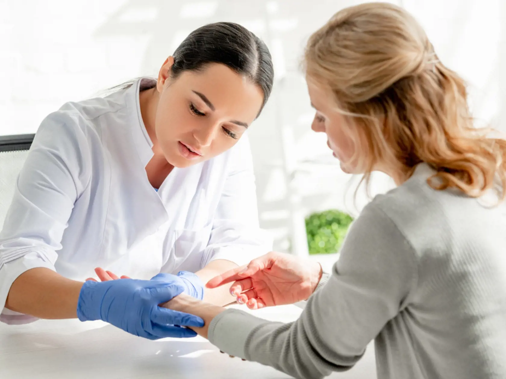 Attractive,Dermatologist,In,White,Coat,Examining,Skin,Of,Patient,In