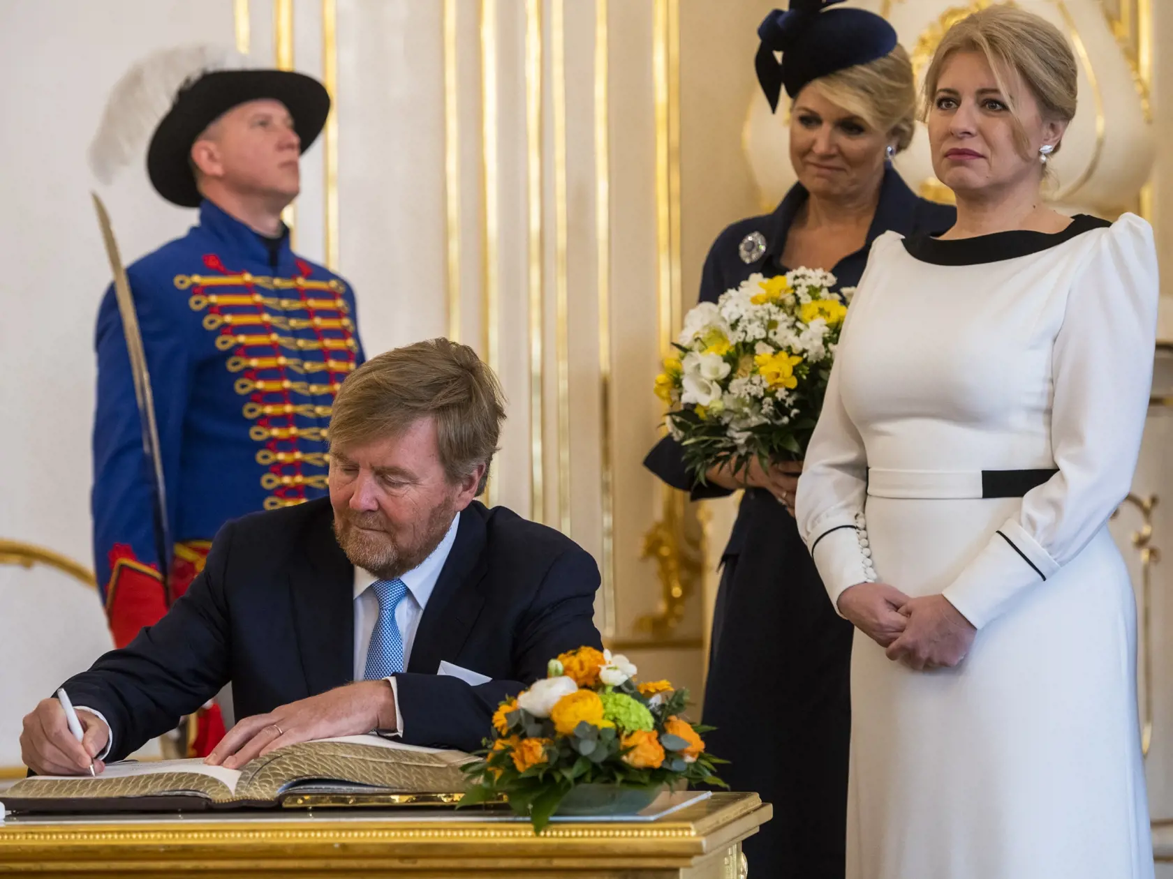 Prezidentka SR Zuzana Čaputová privítala na Slovensku holandského kráľa Viliama Alexandra s kráľovnou Maximou v utorok 7. marca 2023. Ich oficiálna návšteva Slovenska potrvá do štvrtka 9. marca. Okrem Bratislavy navštívi kráľovský pár aj Poprad, Liptovský Mikuláš a Tatranský národný park. Je to po takmer 13 rokoch prvá kráľovská návšteva na Slovensku. Na snímke holandský kráľ Viliam Alexander (druhý vľavo) sa zapisuje do knihy návštev, prizerajú sa holandská kráľovná Maxima (uprostred) a prezide