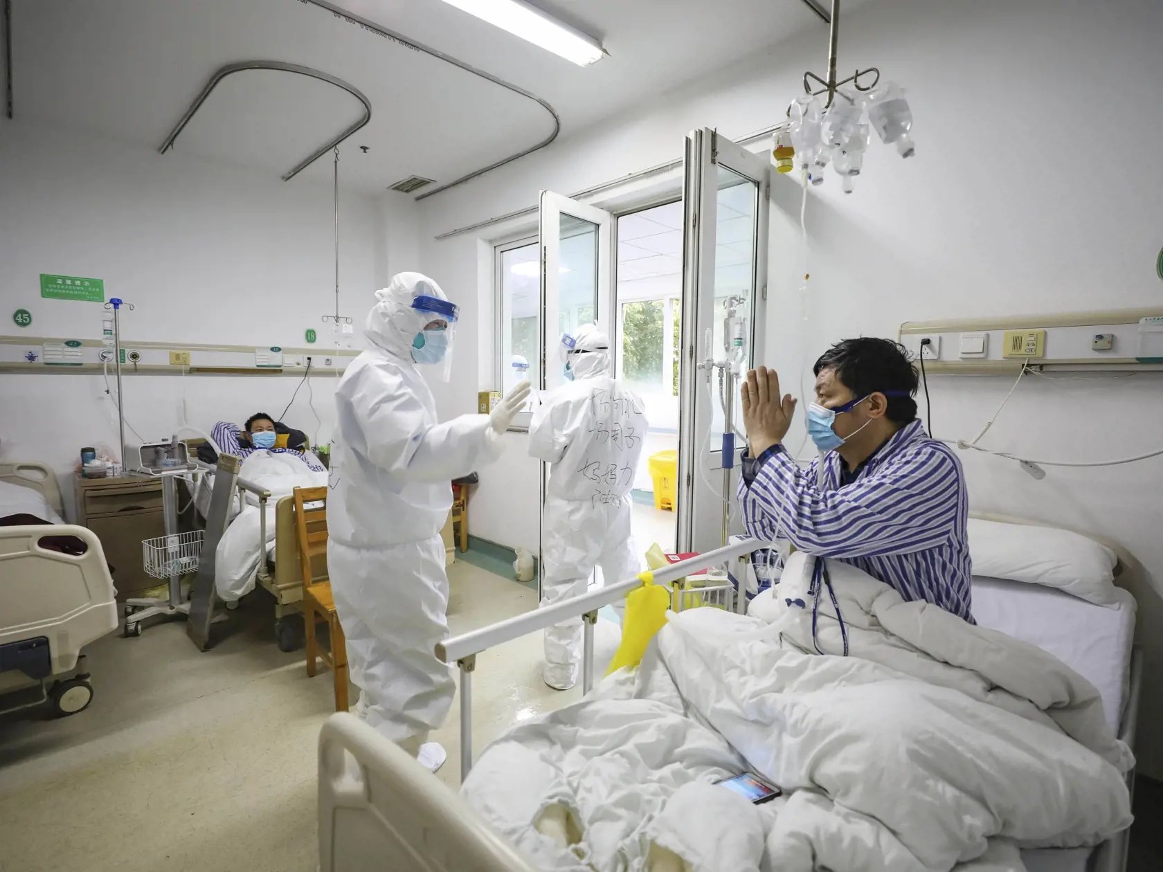 KK8 Wu-chan - Pacient ďakuje doktorovi v nemocnici Ťin-jin-tchan, ktorá je určená pre kritických pacientov s novým smrtiacim koronavírusom spôsobujúcim ochorenie COVID-19, 13. februára 2020 v čínskom Wu-chane. Čína hlásila vo štvrtok 254 nových úmrtí na koronavírus za deň a prudký nárast prípadov nákazy o 15.152 za deň. Údaje prišli po tom, čo v najťažšie postihnutej čínskej provincii Chu-pej začali využívať novú metodológiu na kategorizovanie prípadov infekcie. FOTO TASR/AP
A patient thanks a