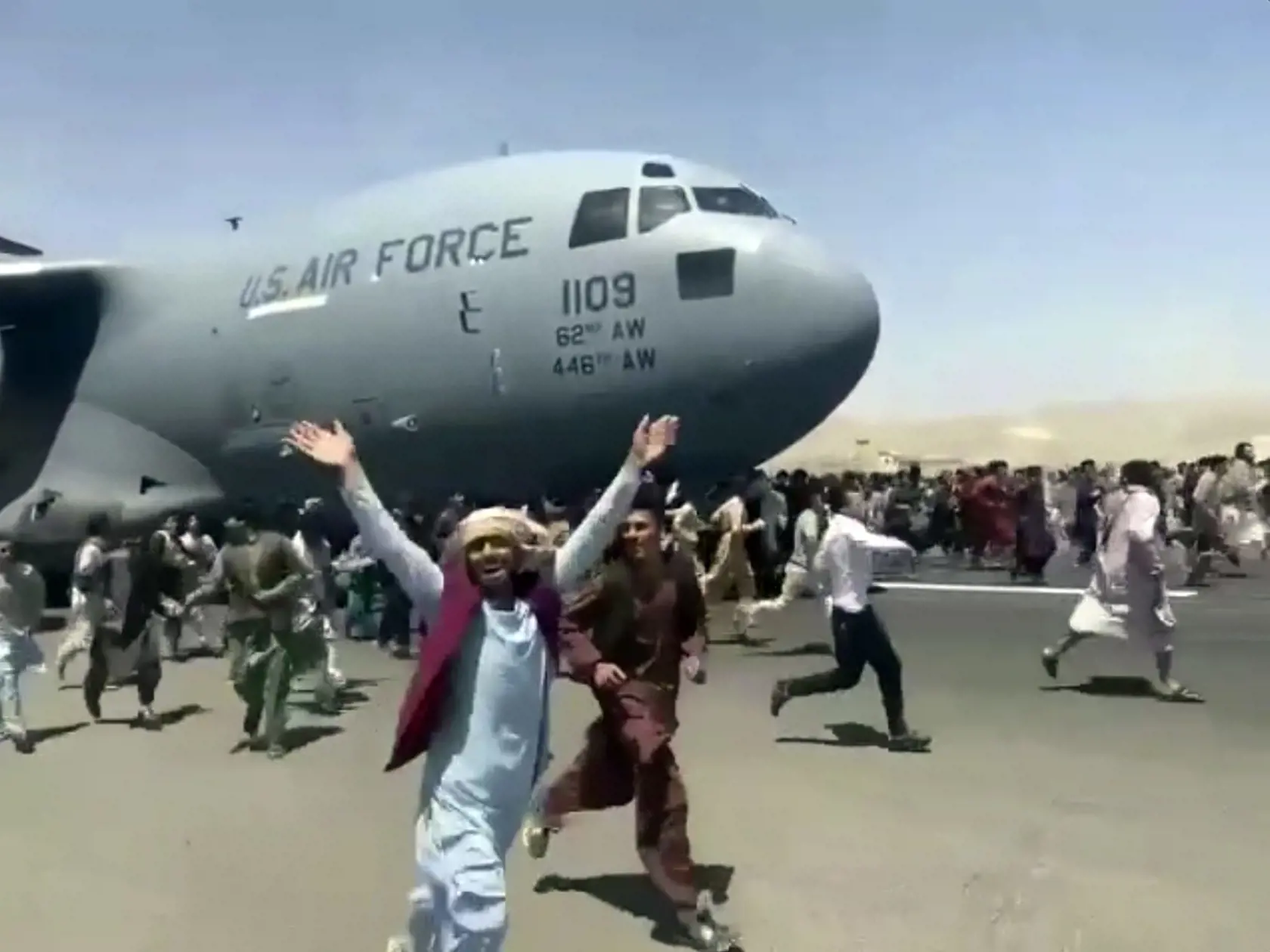 KK20 Kábul -  Ľudia bežia okolo amerického transportného lietadla C-17 na medzinárodnom letisku  Hámida Karzaja v Kábule 16. augusta 2021.  Radikálne hnutie Taliban neočkávane prevzalo v nedeľu 15. augusta moc v Afganistane, čo mu uľahčilo aj stiahnutie amerických a ďalších zahraničných vojakov z krajiny. Náhle zmenená situácia však vyvolala paniku medzi Afgancami, ktorí sa masovo snažia ujsť z vlasti. FOTO TASR/AP
Hundreds of people run alongside a U.S. Air Force C-17 transport plane as it move