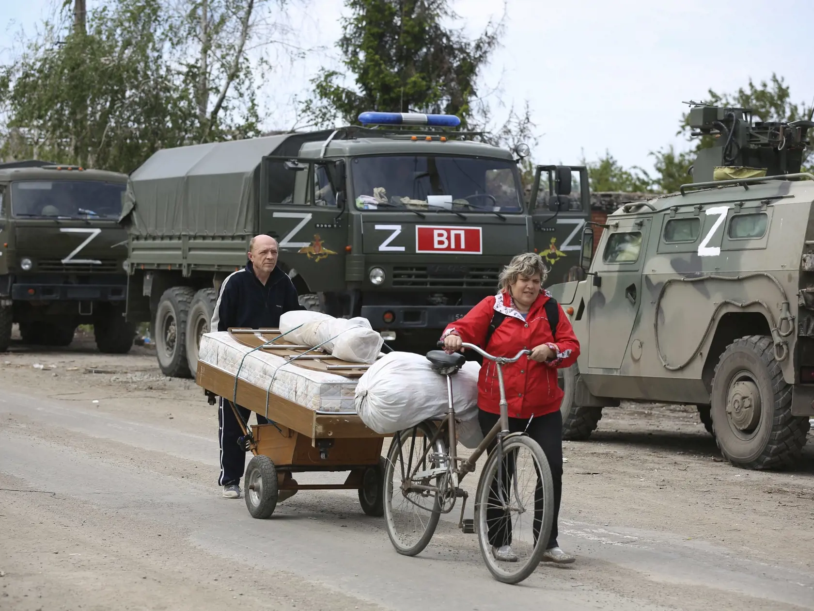WA 33 Mariupol - Miestni obyvatelia kráčajú okolo ruských vojenských vozidiel v obliehanom juhoukrajinskom prístavnom meste Mariupol počas 83. dňa ruskej invázie na Ukrajinu v utorok 17. mája 2022. FOTO TASR/AP   

Local residents walk past Russian military vehicles in Mariupol, in territory under the government of the Donetsk People's Republic, eastern Ukraine, Tuesday, May 17, 2022. (AP Photo/Alexei Alexandrov)